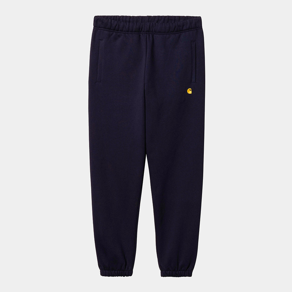 "Dunkelblaue Carhartt WIP Chase Sweat Pant mit goldenem Logo-Stick und elastischen Bündchen in der Frontansicht bei Stickabush Berlin."