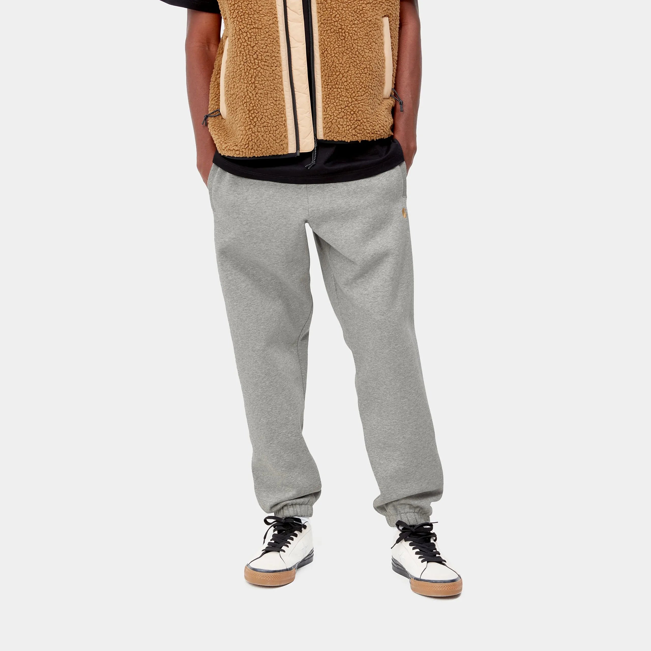 "Carhartt Chase Sweat Pant in Grau meliert/Gold, Baumwollmischung, elastischer Bund, goldene Logo-Stickerei bei Stickabush Berlin."