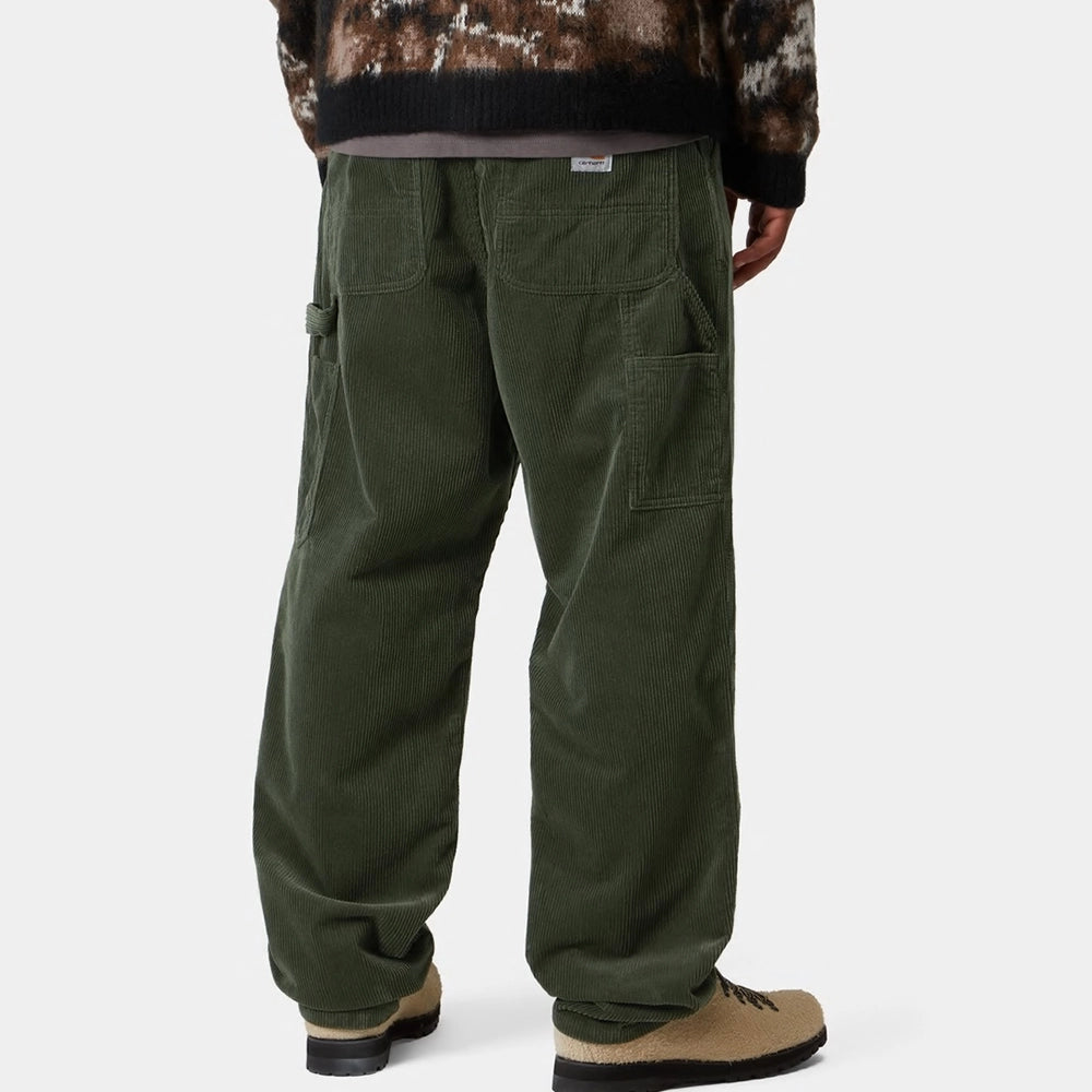 "Grüne Workwear Cordhose von Carhartt WIP im Workwear-Stil, mit geradem Bein, Gesäßtaschen und Werkzeugtaschen am Oberschenkel.“