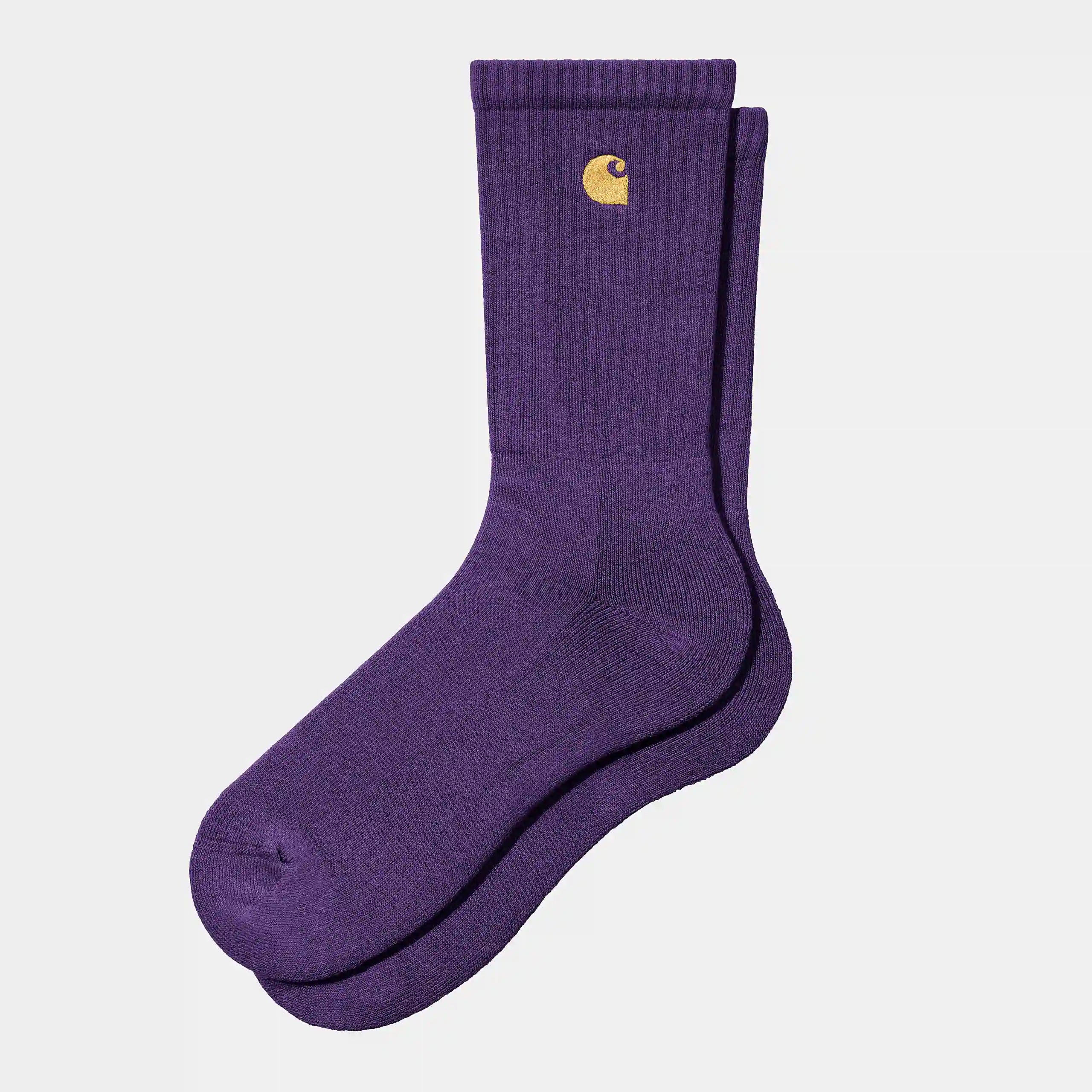 Carhartt WIP Chase Socks – Tyrian / Gold. Lila Socken aus Baumwoll-Mix, mit geripptem Schaft und gesticktem, goldenem Carhartt WIP Logo am Knöchel.