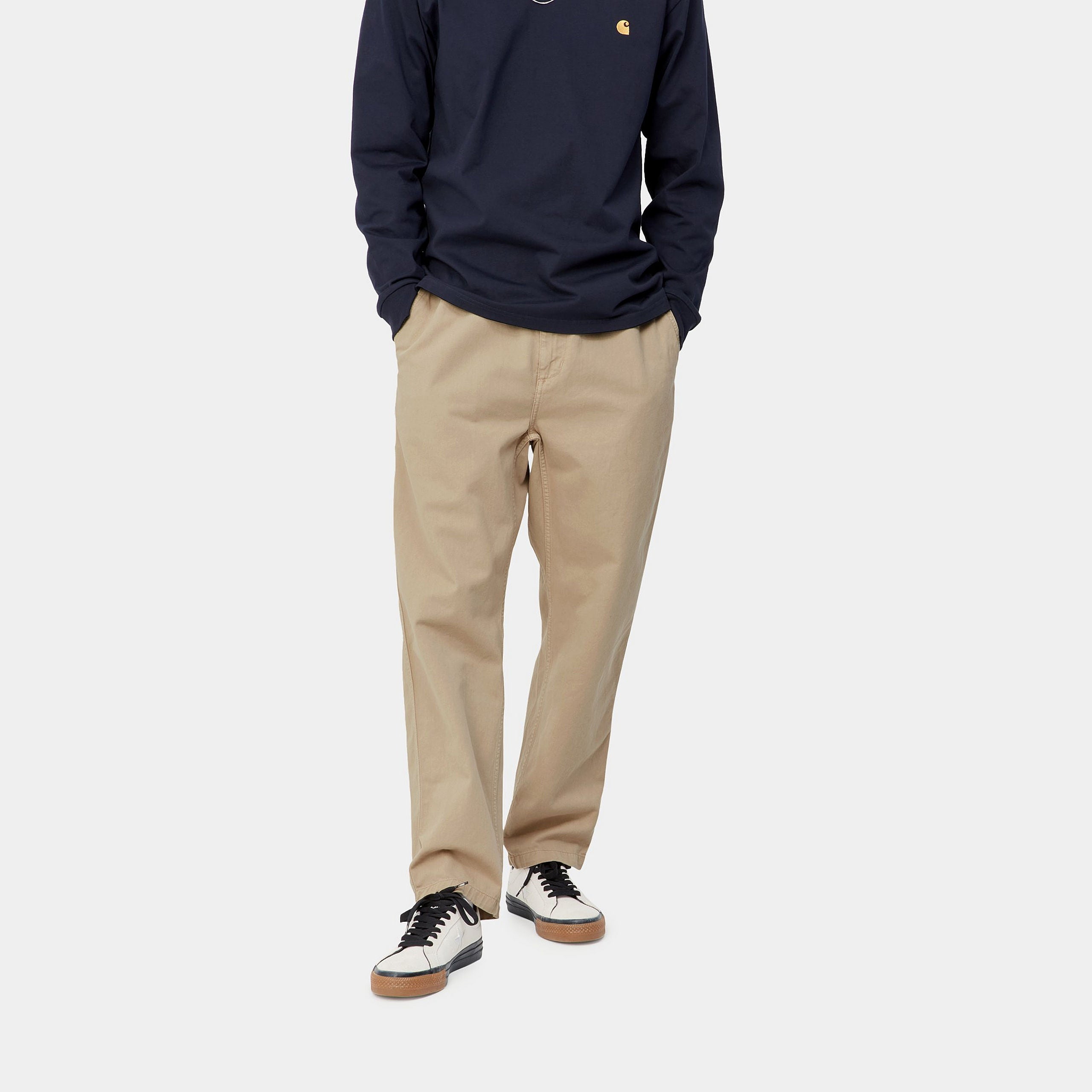 "Carhartt WIP Flint Pant – Wall (garment dyed). Beigefarbene Stoffhose aus Baumwoll-Cord, mit lockerer Passform und Carhartt WIP Square Label am Gesäß."
