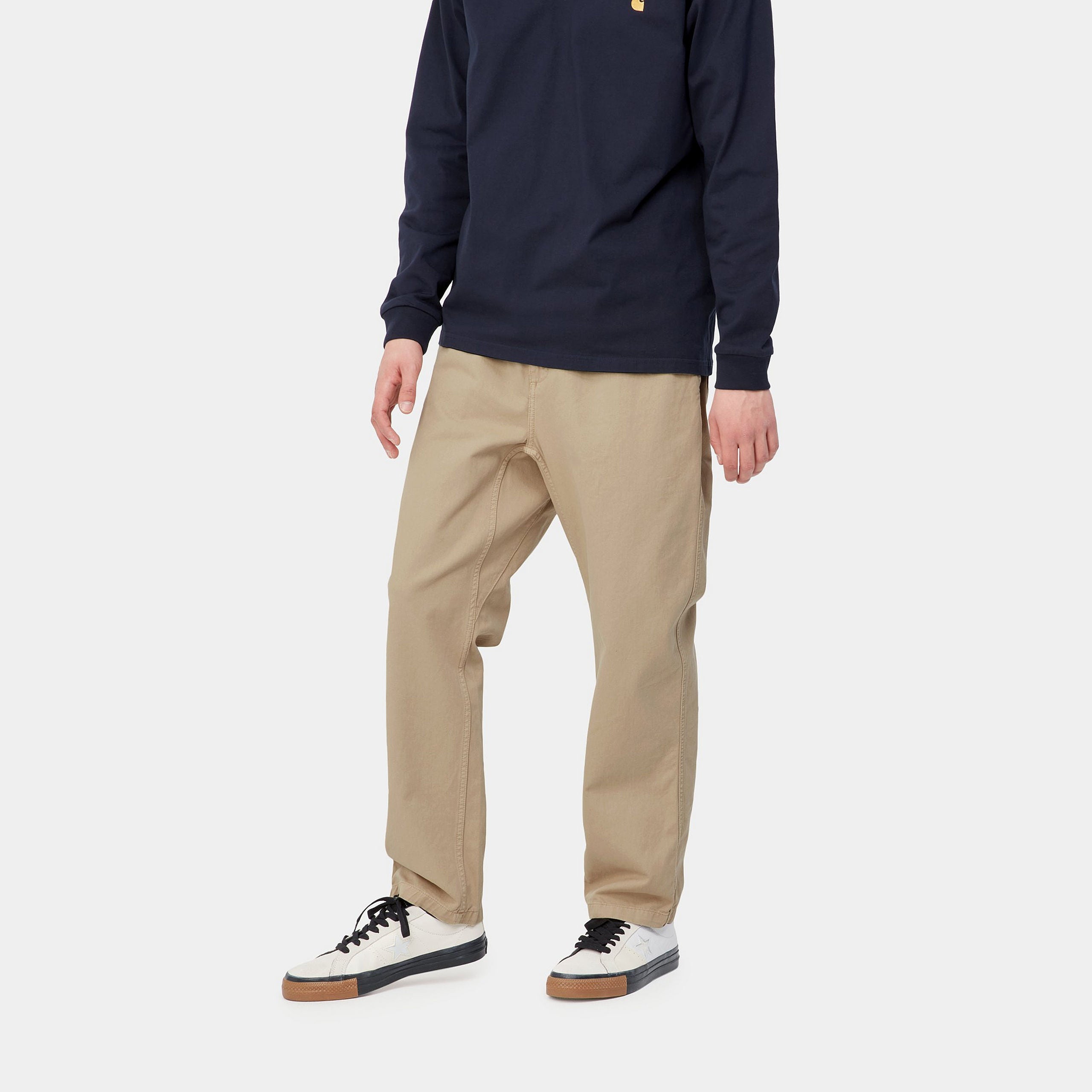 "Carhartt WIP Flint Pant – Wall (garment dyed). Beigefarbene Stoffhose aus Baumwoll-Cord, mit lockerer Passform und Carhartt WIP Square Label am Gesäß."
