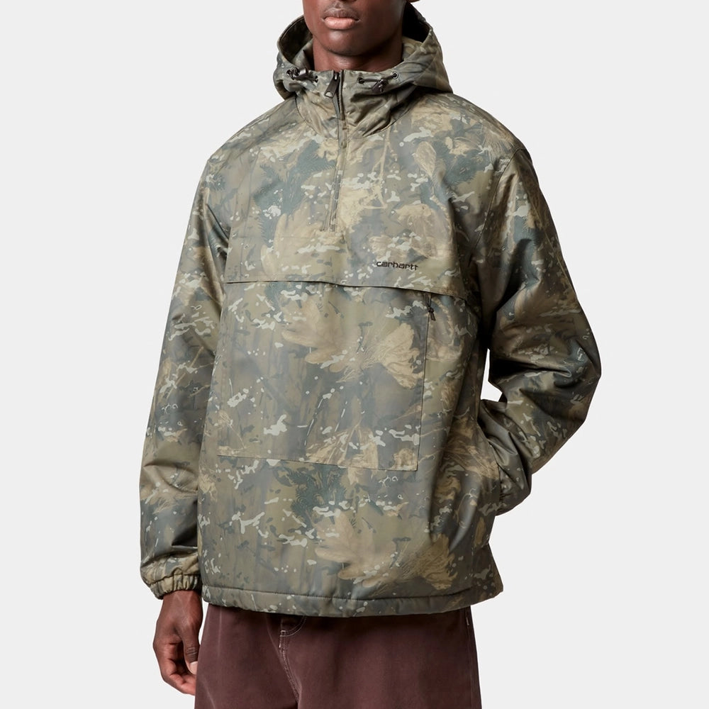 “Carhartt WIP Winter-Windbreaker in Camouflage-Grün. Gefütterter Pullover aus wasserabweisendem Nylon-Taft, mit Kängurutasche erhältlich bei Stickabush Berlin.“