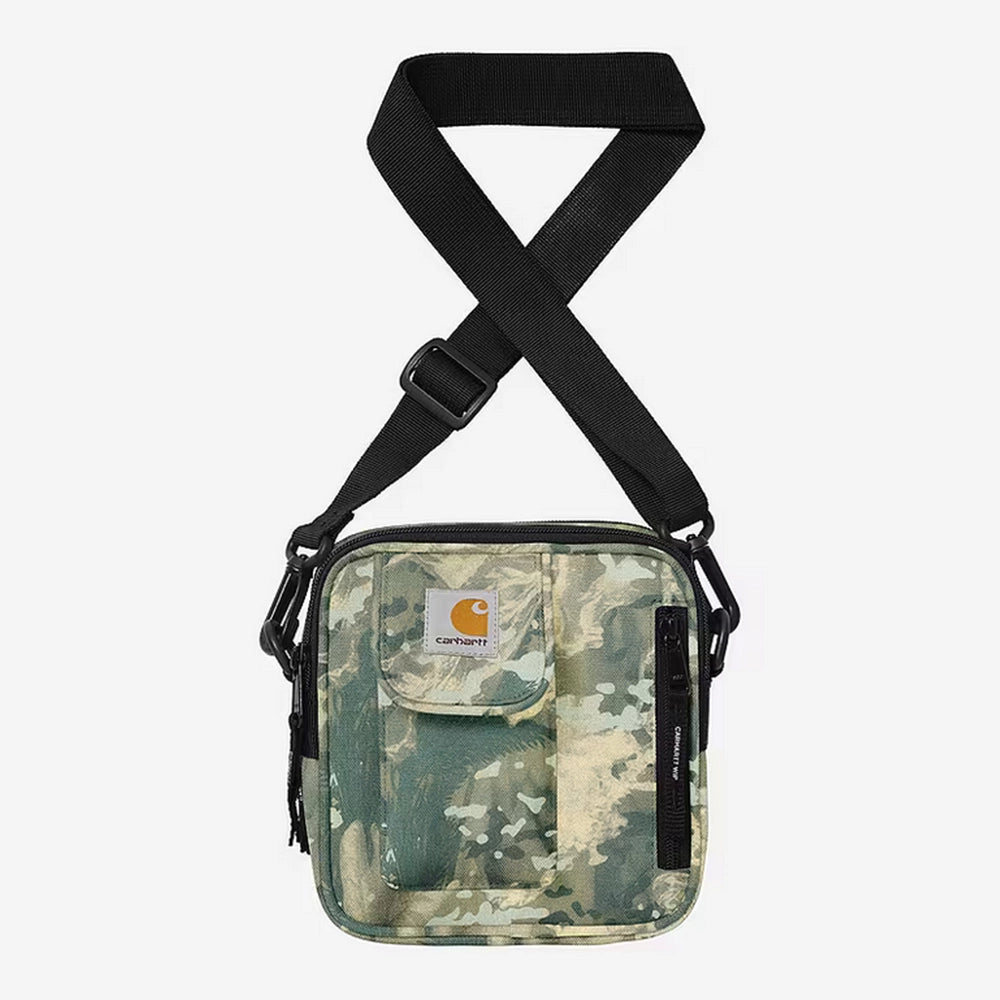 “Carhartt WIP Essentials Bag, Small – Camo Combi, Green. Grüne Umhängetasche aus Polyester-Duck-Canvas, mit verstellbarem Schultergurt, Reißverschlüssen und Carhartt WIP Logo auf der Vorderseite.“