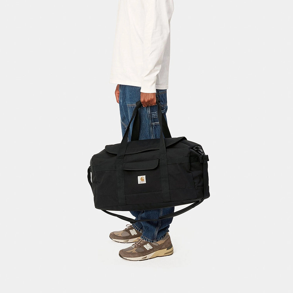 "Carhartt Jack Duffle Bag in Schwarz, robustes Gewebe, große Reisetasche mit Tragegriffen und Schultergurt, Logo-Patch."
