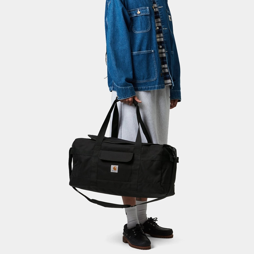 "Carhartt Jack Duffle Bag in Schwarz, robustes Gewebe, große Reisetasche mit Tragegriffen und Schultergurt, Logo-Patch."