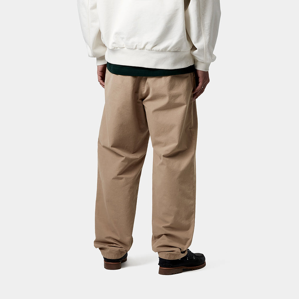 "Carhartt WIP Calder Pant – Leather. Braune Hose aus strapazierfähigem Baumwoll-Twill, locker geschnitten, mit fünf Taschen, Knopfleiste und gewebtem Carhartt WIP Logo."