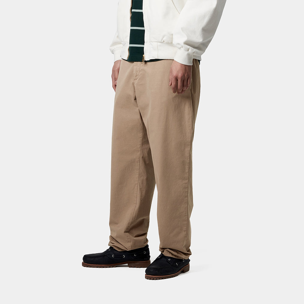 "Carhartt WIP Calder Pant – Leather. Braune Hose aus strapazierfähigem Baumwoll-Twill, locker geschnitten, mit fünf Taschen, Knopfleiste und gewebtem Carhartt WIP Logo."
