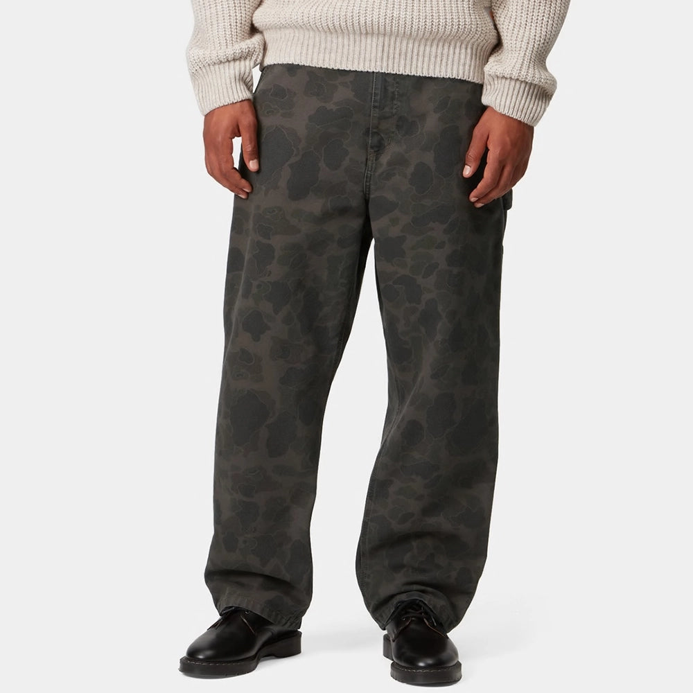 “Carhartt WIP Duck Single Knee Pant in Camo Duck. Robuste Workwear Canvas-Hose in Grün/Porphyr-Färbung mit Werkzeugtaschen und Hammerschlaufe.“
