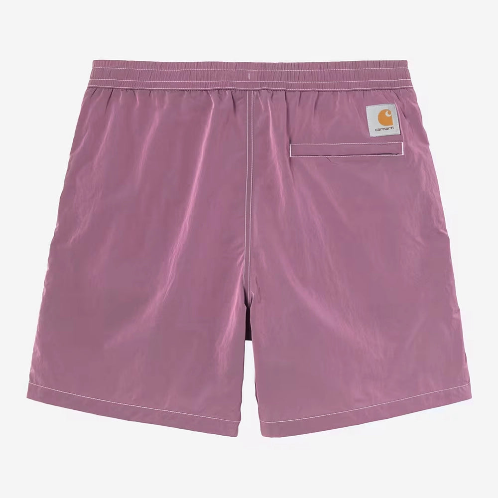 “Carhartt WIP Canby Swim Trunks in Gentle Purple Lila mit weißem Logo-Schriftzug, lässige Badehose mit Mesh-Innentasche bei Stickabush Berlin.“ 