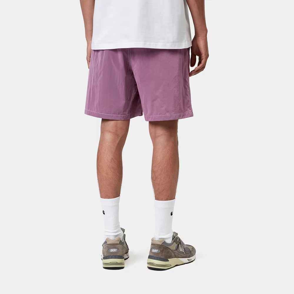 “Carhartt WIP Canby Swim Trunks in Gentle Purple Lila mit weißem Logo-Schriftzug, lässige Badehose mit Mesh-Innentasche bei Stickabush Berlin.“ 