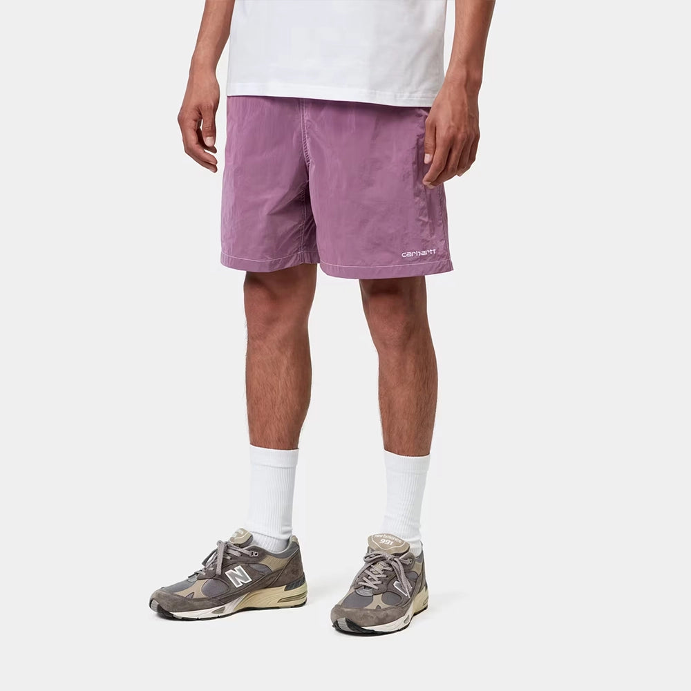 “Carhartt WIP Canby Swim Trunks in Gentle Purple Lila mit weißem Logo-Schriftzug, lässige Badehose mit Mesh-Innentasche bei Stickabush Berlin.“ 