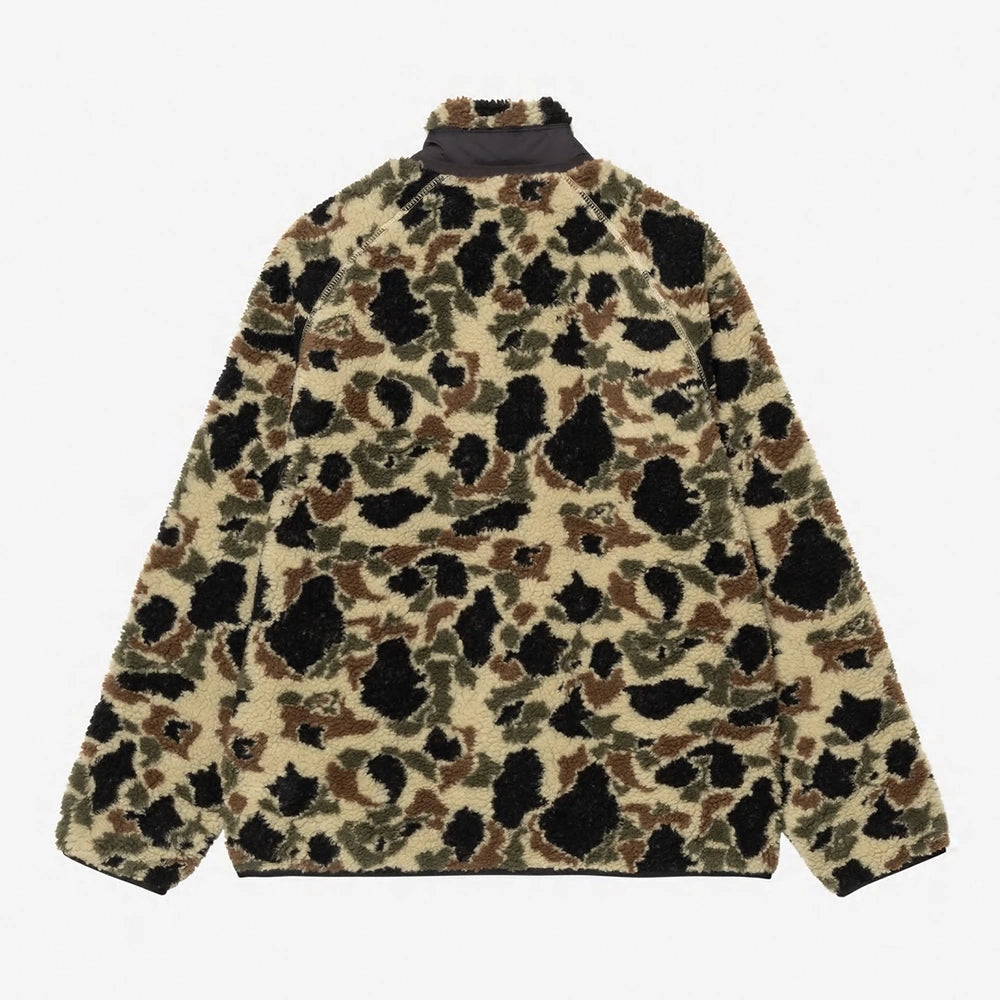 "Beige farbene Fleece-Jacke mit schwarz, grün und braunem Camouflage-Muster. Sie hat eine Nylon-Brusttasche mit Reißverschluss und das Carhartt-Logo.“