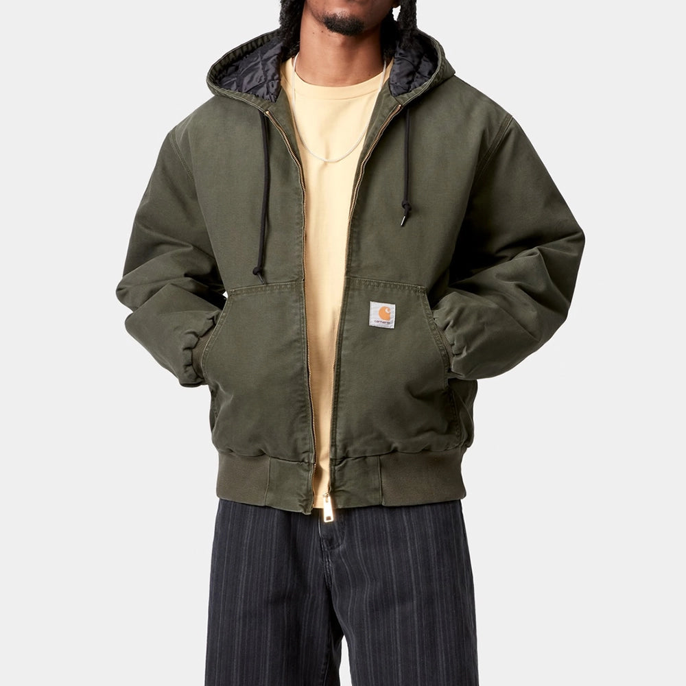 “Carhartt WIP OG Active Jacket in Olive. Stone Washed Canvas Jacke mit Kapuze, gestepptem Futter und Kängurutasche bei Stickabush Berlin.“