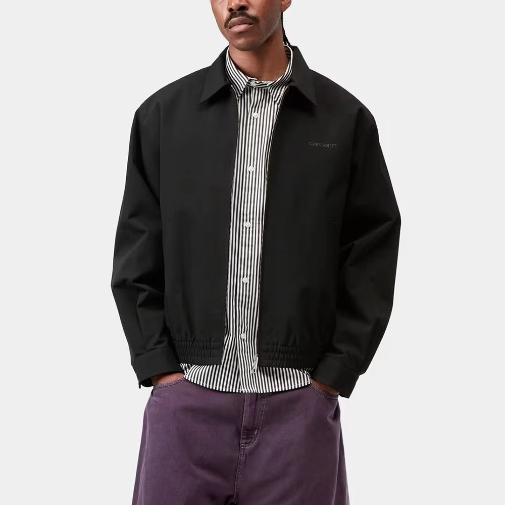 "Carhartt WIP Neven Jacket in Black/Graphite mit sichtbarem Square-Label auf der Brusttasche und technischem Reißverschluss bei Stickabush Berlin."