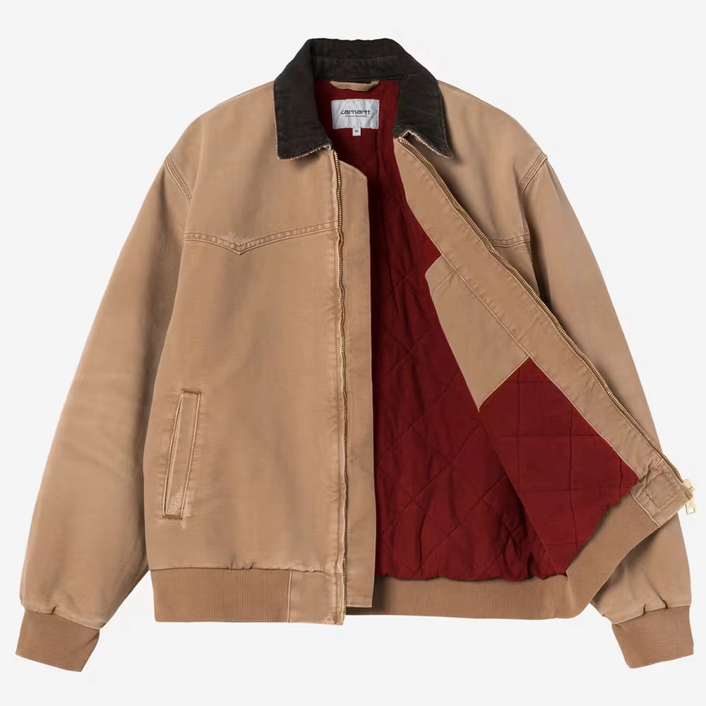 "Carhartt WIP OG Santa Fe Jacke in Hamilton Brown mit dunkelbraunem Cord-Kragen und dem quadratischen Carhartt Logo-Label am Saum bei Stickabush Berlin."