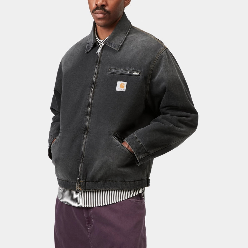 „Carhartt WIP OG Detroit Jacket in Schwarz, robuste Baumwolle im Used-Look, mit Frontzipper und Brusttasche.“