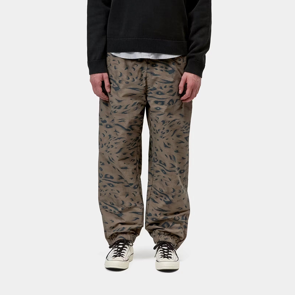 Carhartt WIP Travon Pant in Duck Feather Print Cypress / Black – Vorderansicht am Model der wasserabweisenden Hose mit Entenfeder-Muster und Stickereien.