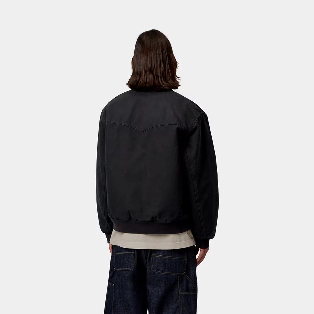 Carhartt WIP OG Santa Fe Jacket in Black / Black – Rueckansicht am Model der schwarzen Stone-Canvas-Workwear-Jacke mit farblich abgesetzten Cord-Details und Reißverschlusstasche.