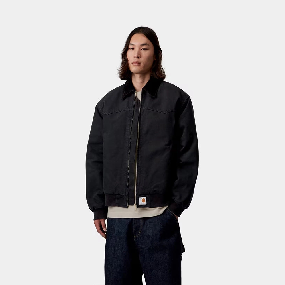 Carhartt WIP OG Santa Fe Jacket in Black / Black – Vorderansicht am Model der schwarzen Stone-Canvas-Workwear-Jacke mit farblich abgesetzten Cord-Details und Reißverschlusstasche.