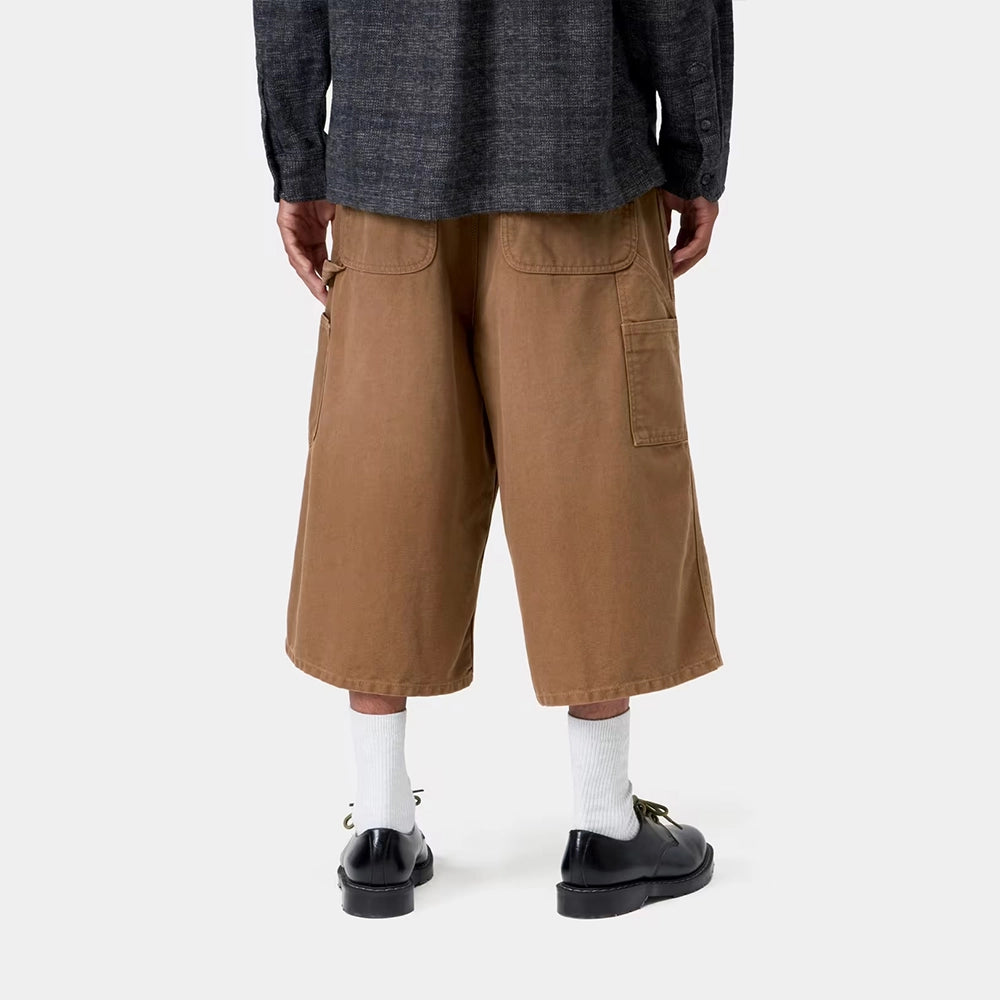 Carhartt WIP OG Single Knee Long Short in WIP H Brown – Rueckansicht Outfit am Model der braunen Canvas-Workwear-Shorts mit Tool-Taschen und Hammerlasche.