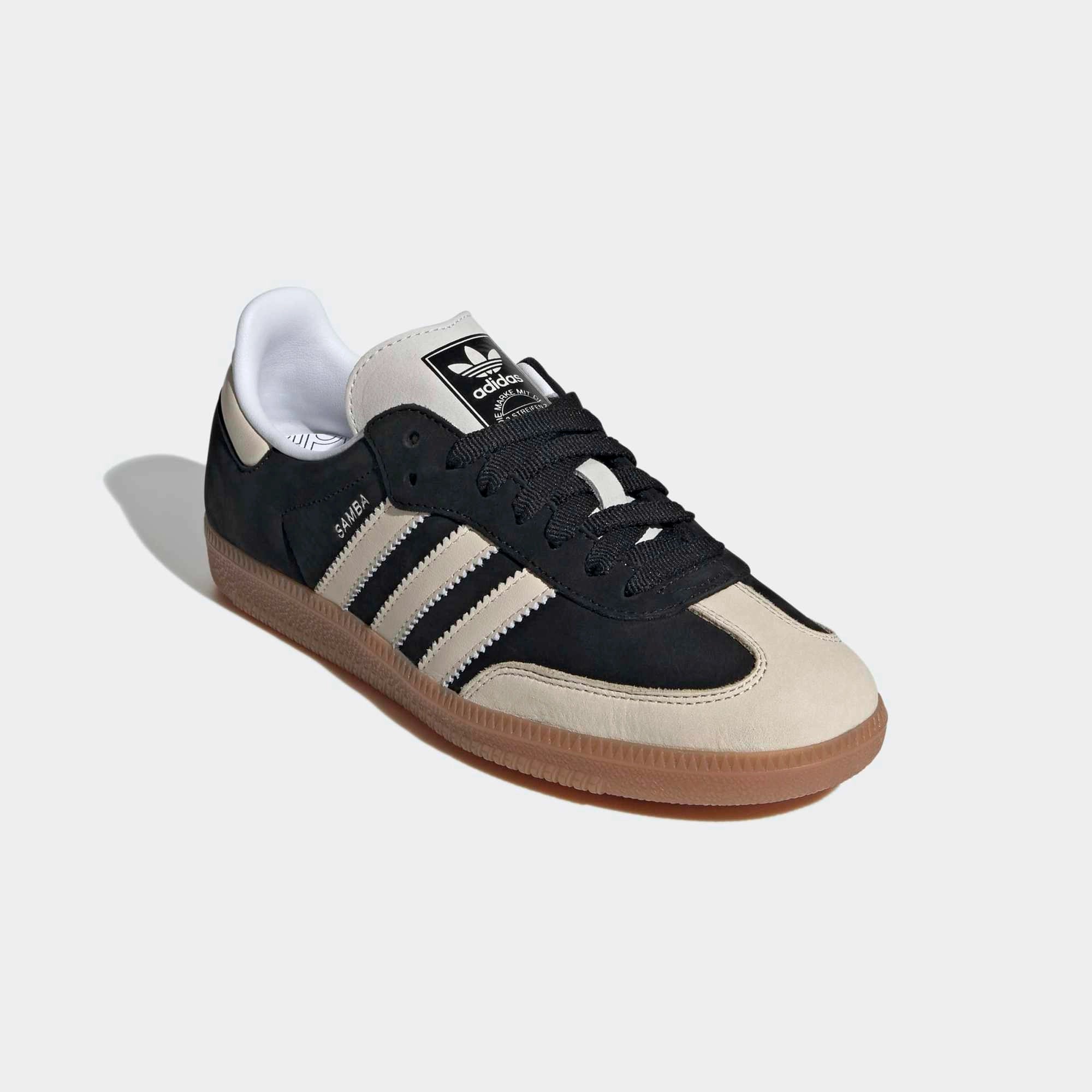 Adidas Samba OG Sneaker in Schwarz. Gefertigt aus Leder und Wildleder, mit beigefarbenem 3-Streifen und silberfarbenem Samba-Schriftzug.