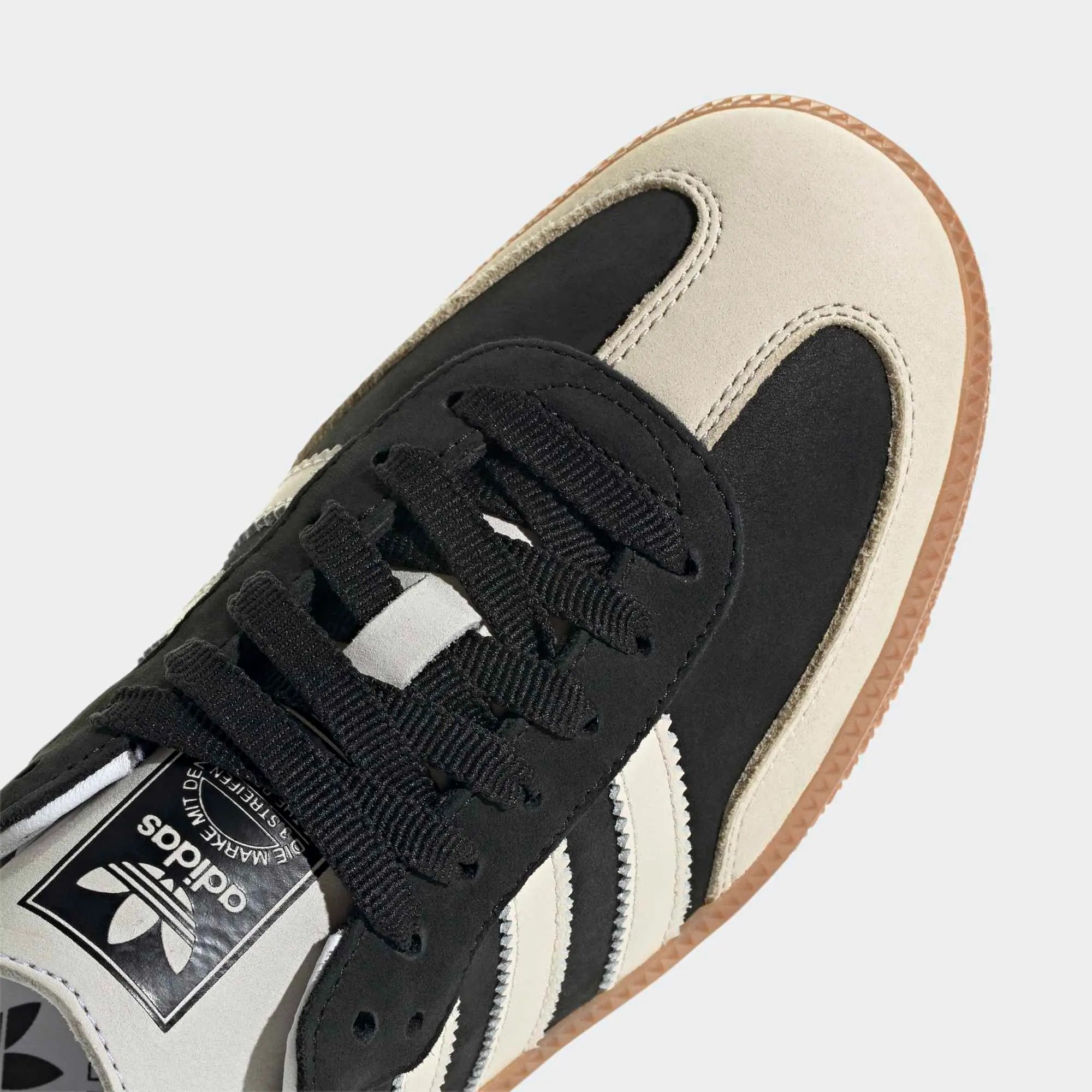 Adidas Samba OG Sneaker in Schwarz. Gefertigt aus Leder und Wildleder, mit beigefarbenem 3-Streifen und silberfarbenem Samba-Schriftzug.