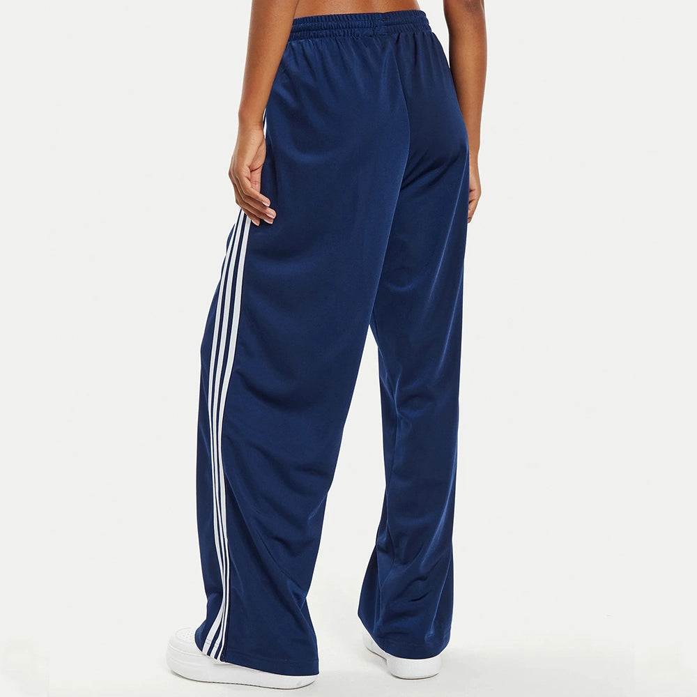 “Adidas Firebird Track Pants Loose Fit W in Dunkelblau. Lockere Hose aus glänzendem Trikotstoff, mit weißen 3-Streifen und gesticktem Logo.“