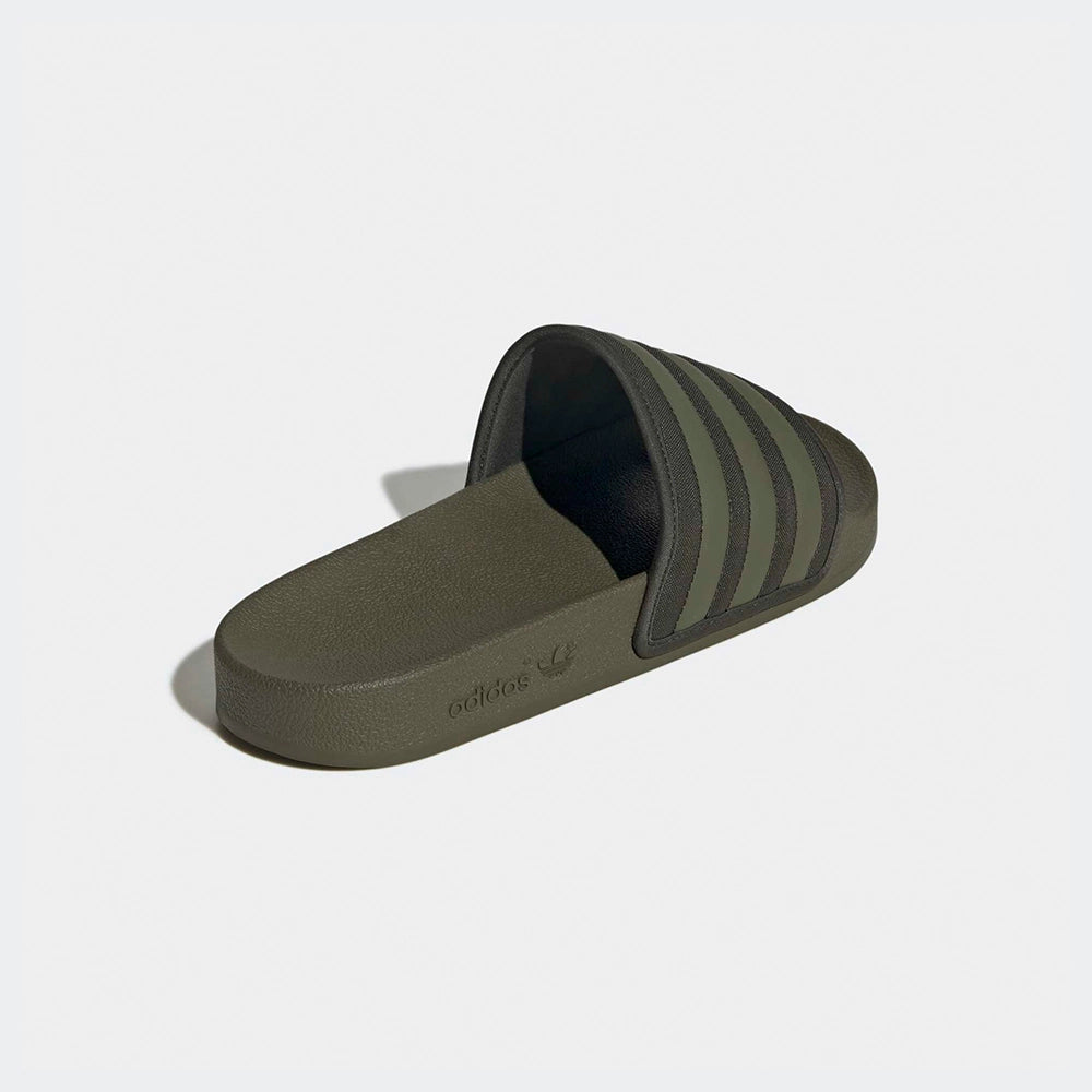 "Slipper von Adidas Adilette in Olivgrün mit einem breiten Riemen mit den drei weißen Streifen und einem vorgeformten Fußbett.“