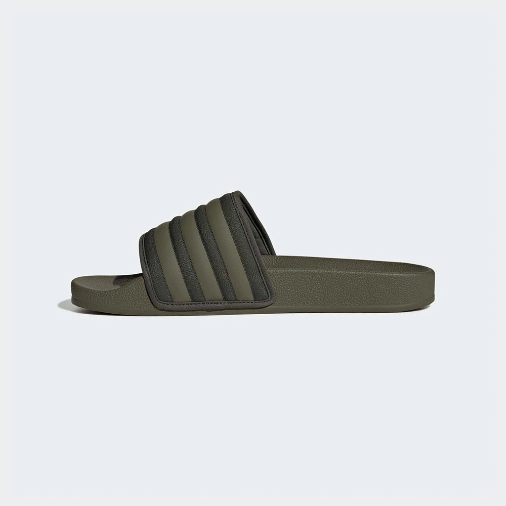 "Slipper von Adidas Adilette in Olivgrün mit einem breiten Riemen mit den drei weißen Streifen und einem vorgeformten Fußbett.“