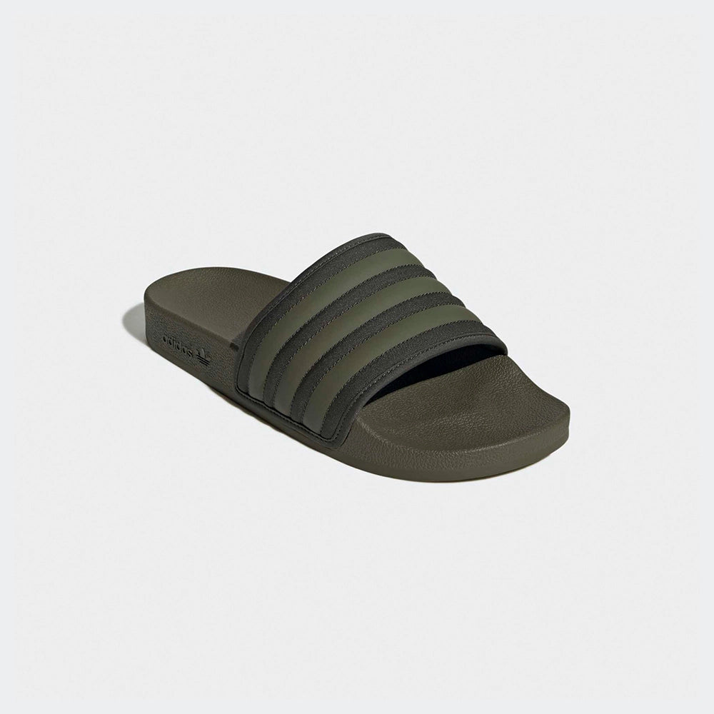 "Slipper von Adidas Adilette in Olivgrün mit einem breiten Riemen mit den drei weißen Streifen und einem vorgeformten Fußbett.“