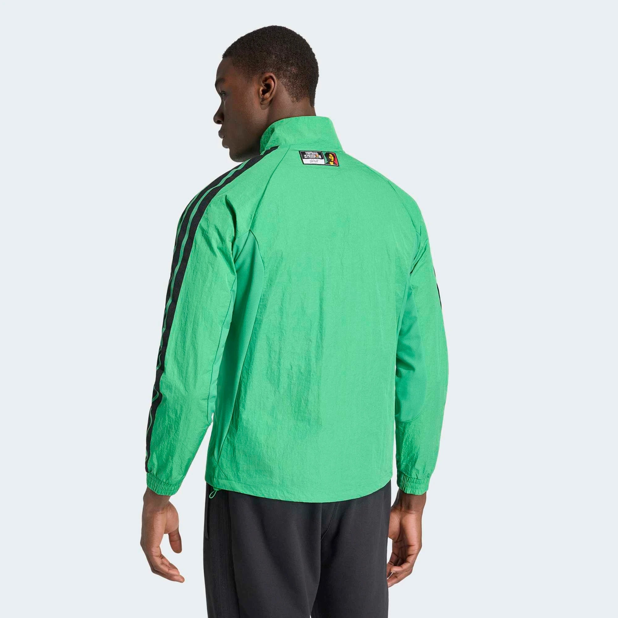 “Adidas Originals Jamaica Home Anthem Jacket in Vivid Green mit gelb-schwarzen Details und dem Logo des jamaikanischen Fußballverbandes bei Stickabush Berlin.“