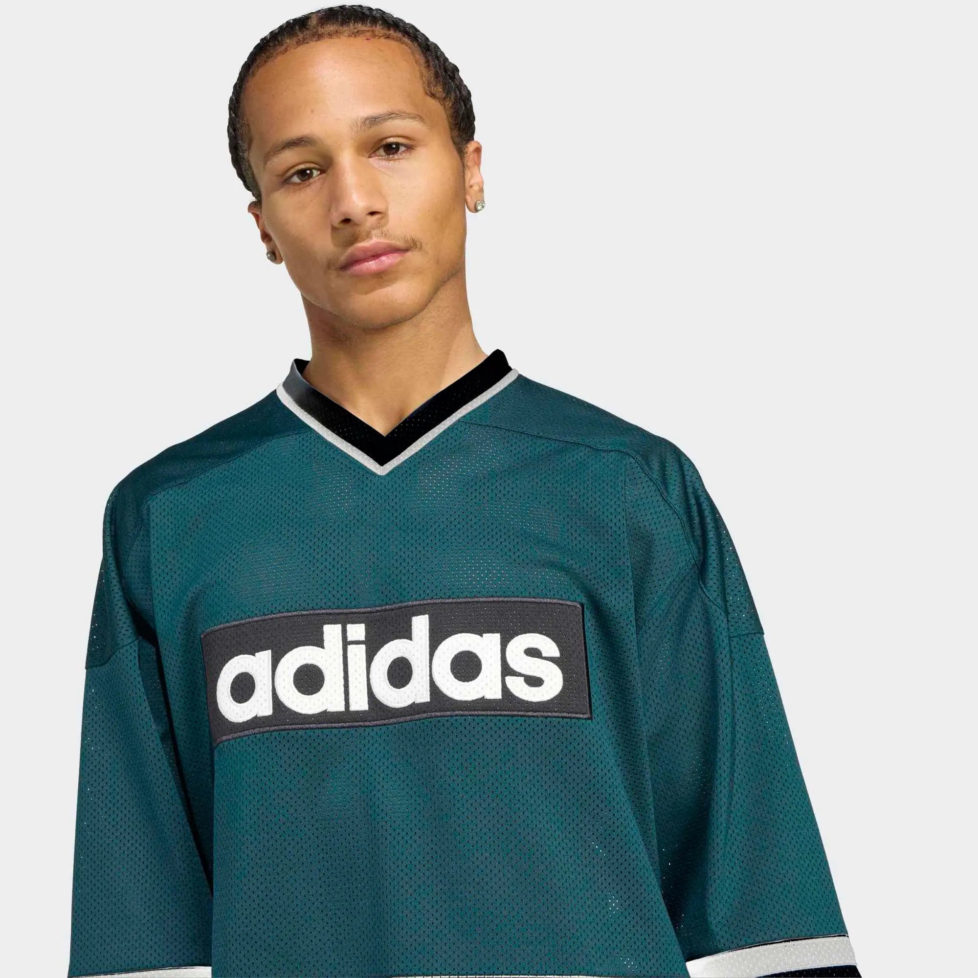 "Grünes adidas Originals Hockey Jersey (Aurora Ivy) mit V-Ausschnitt, weißen Kontraststreifen und Trefoil-Logo auf der Brust bei Stickabush Berlin."