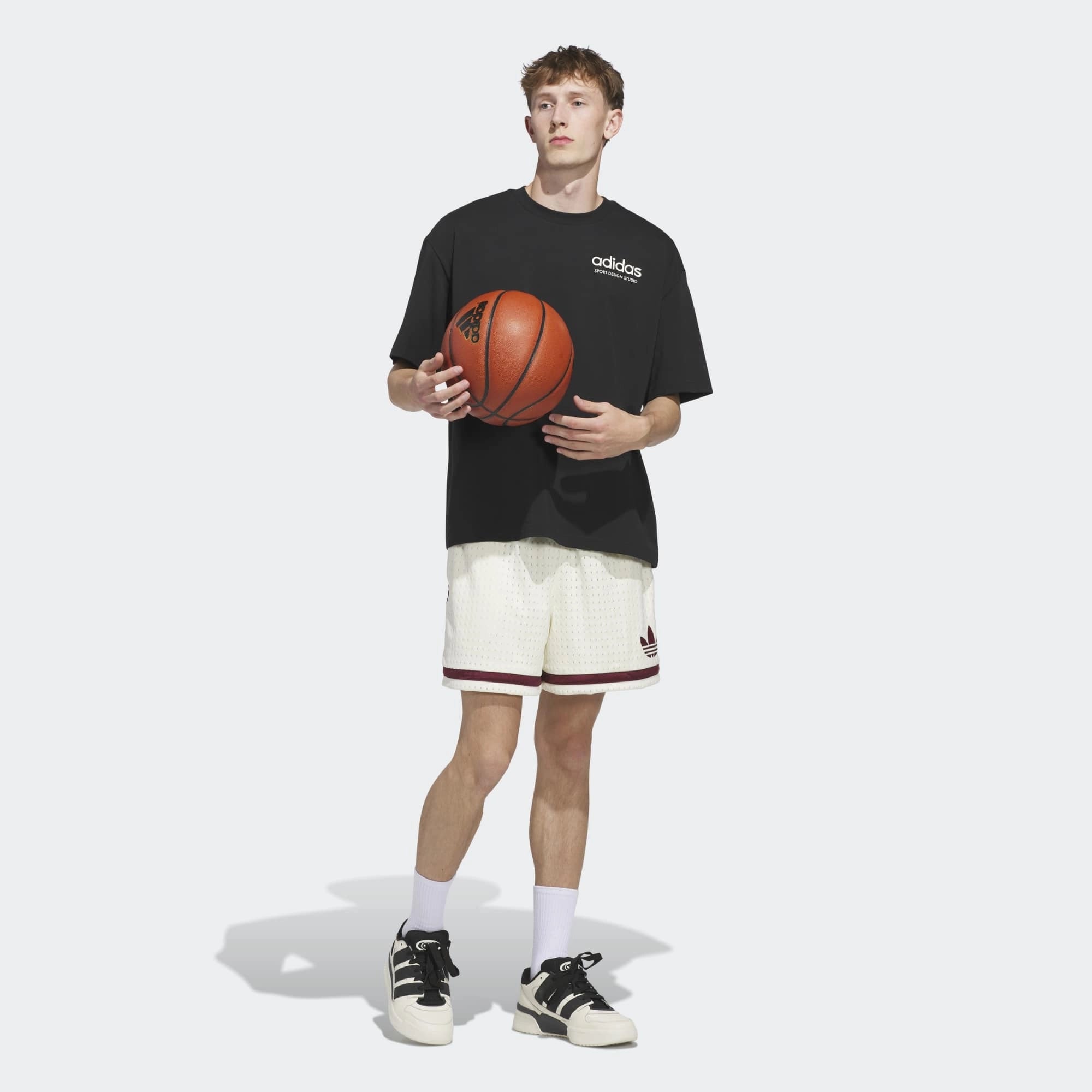 „Vorderansicht Model Outfit des adidas Originals Sport Design GFX Tee in Schwarz mit zentralem Retro-Sportgrafik-Print bei Stickabush Berlin.“
