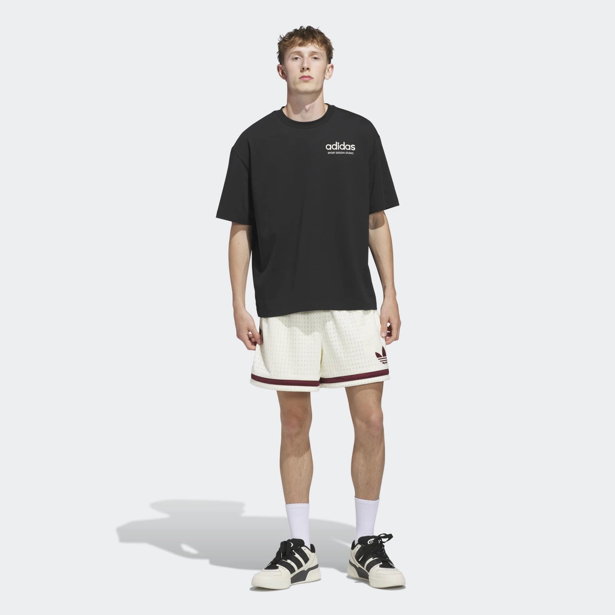 „Vorderansicht Model Outfit des adidas Originals Sport Design GFX Tee in Schwarz mit zentralem Retro-Sportgrafik-Print bei Stickabush Berlin.“