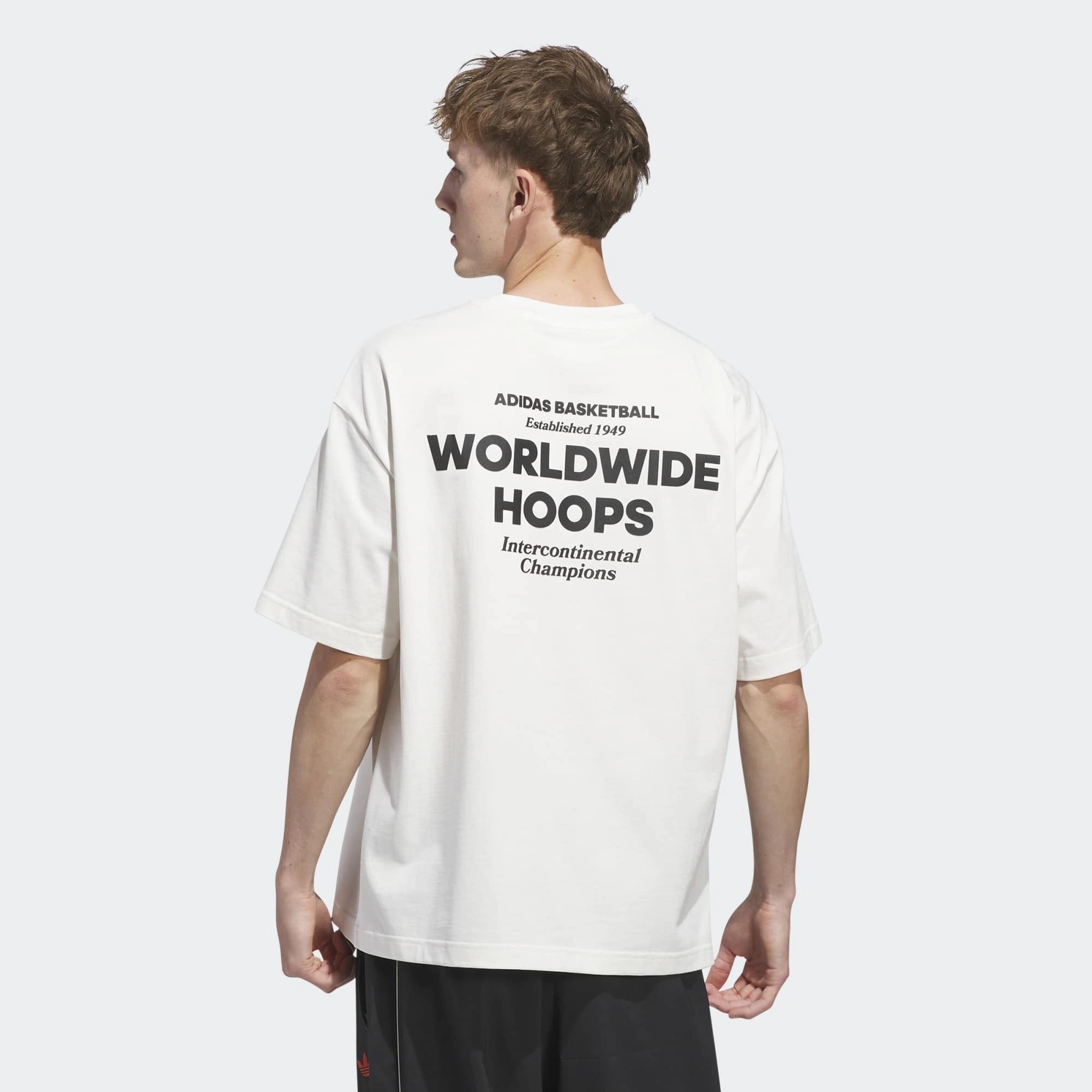 „Hinteransicht des Adidas Originals Worldwide Hoops GFX Tee in Cloud White – Weißes Baumwoll-T-Shirt mit schwarzem Basketball-Grafikprint bei Stickabush Berlin.“