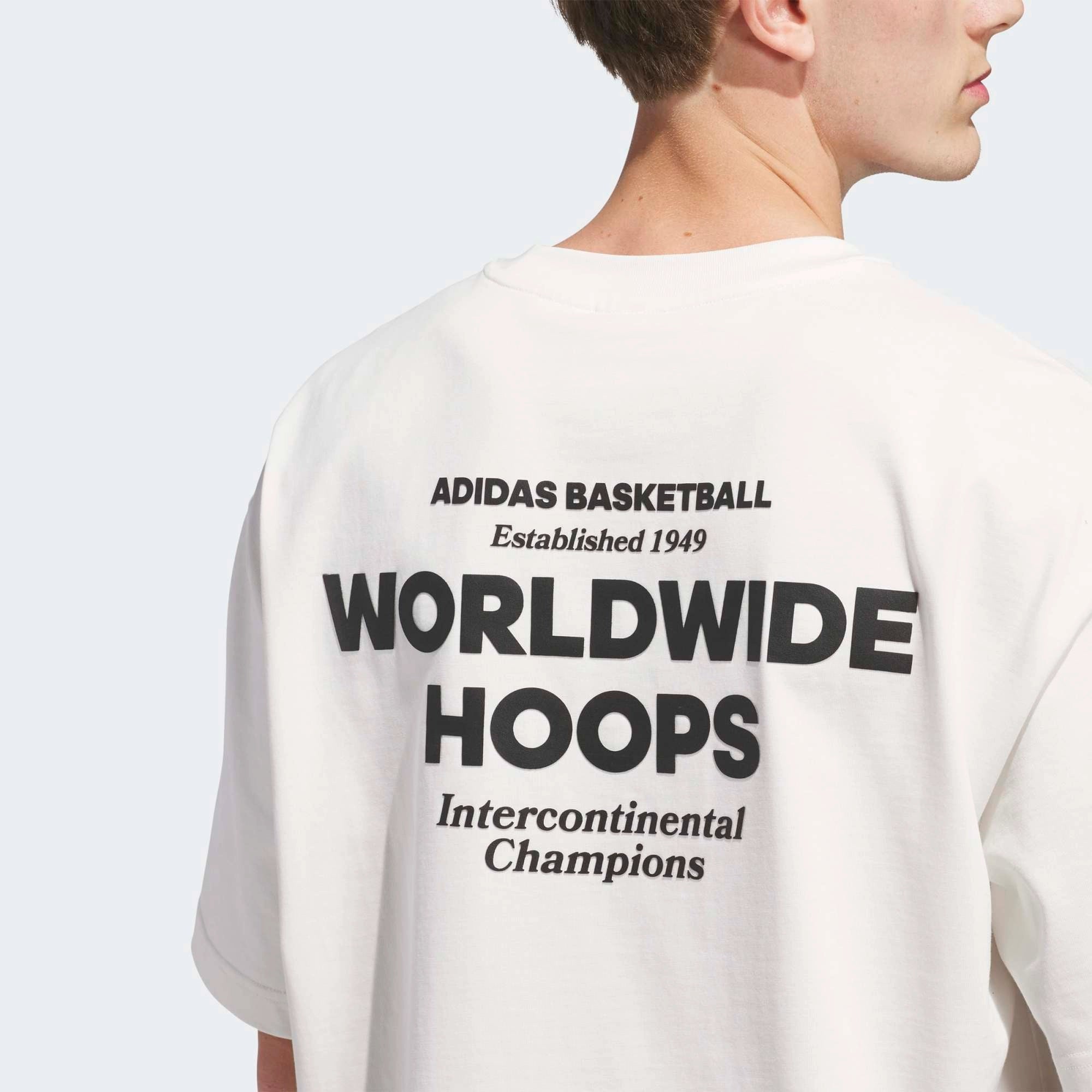 „Rückansicht Print Model des Adidas Originals Worldwide Hoops GFX Tee in Cloud White – Weißes Baumwoll-T-Shirt mit schwarzem Basketball-Grafikprint bei Stickabush Berlin.“