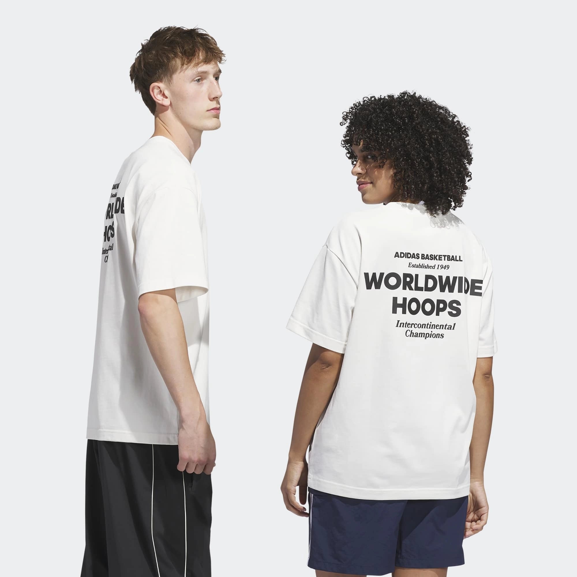 „Rückansicht Models des Adidas Originals Worldwide Hoops GFX Tee in Cloud White – Weißes Baumwoll-T-Shirt mit schwarzem Basketball-Grafikprint bei Stickabush Berlin.“