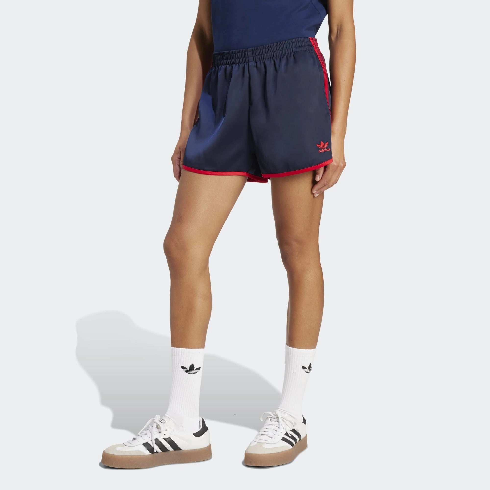 Adidas 3-Stripes Sprinter Shorts in Dunkelblau. Hergestellt aus recyceltem Polyester, mit leuchtend roten 3-Streifen an den Seiten.