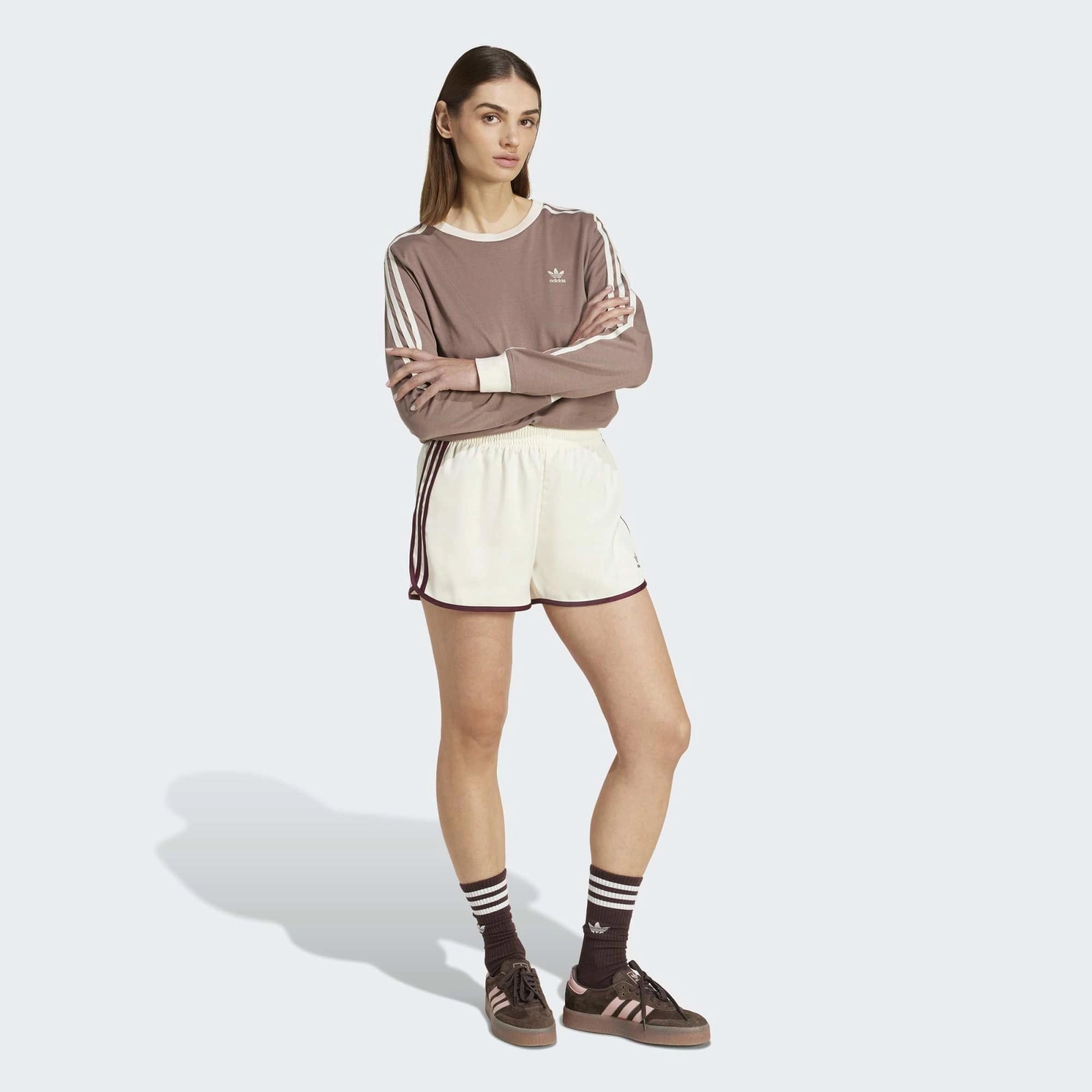 “adidas Originals 3-Stripes Sprinter Shorts W. Kurze, cremefarbene Damenshorts aus recyceltem Polyester, mit elastischem Bund, drei bordeaux-roten Seitenstreifen und gesticktem Trefoil-Logo bei Stickabush.“