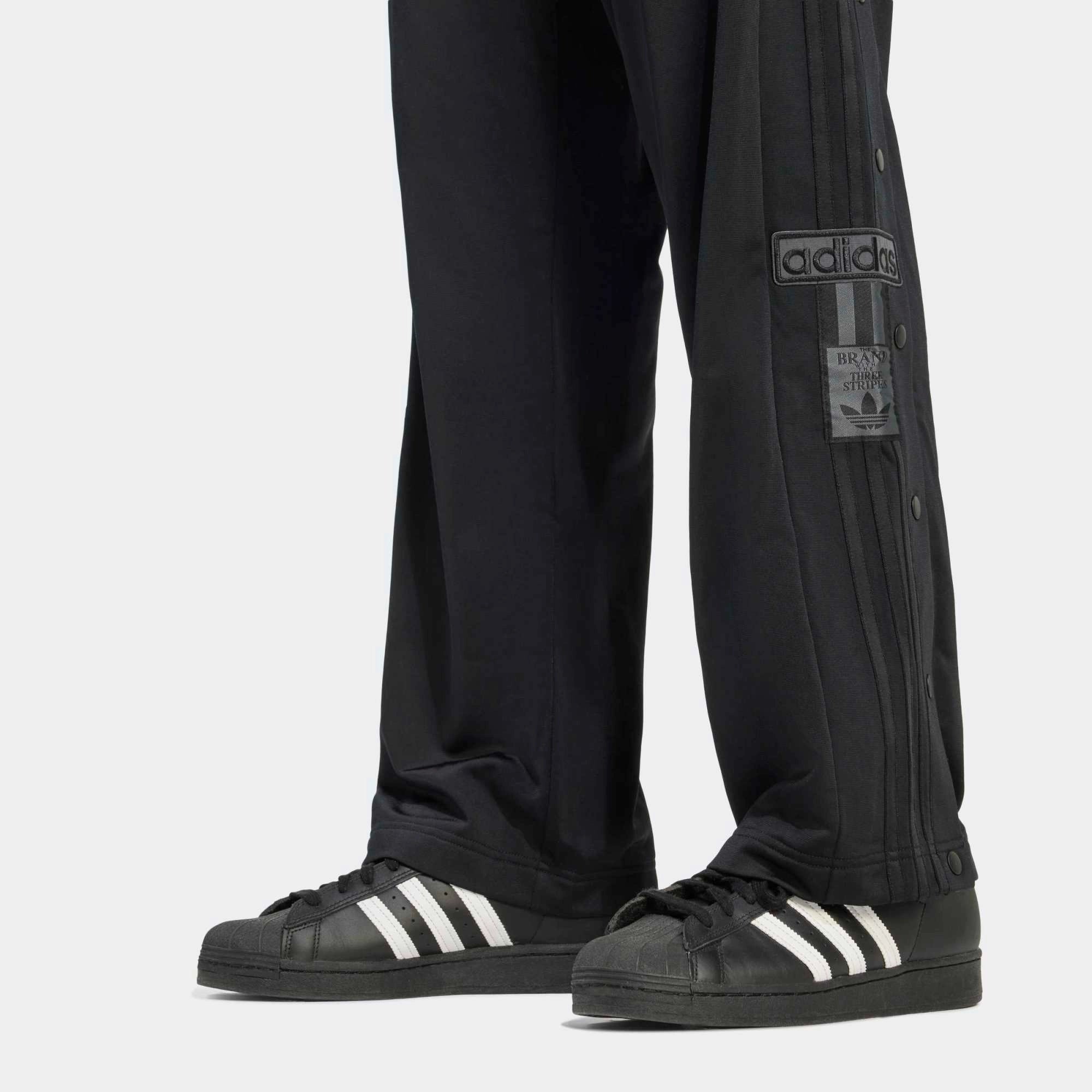 "adidas Originals Adibreak Track Pants Herren All Black, weites Bein mit Druckknopfleiste, tonale 3-Streifen bei Stickabush.“
