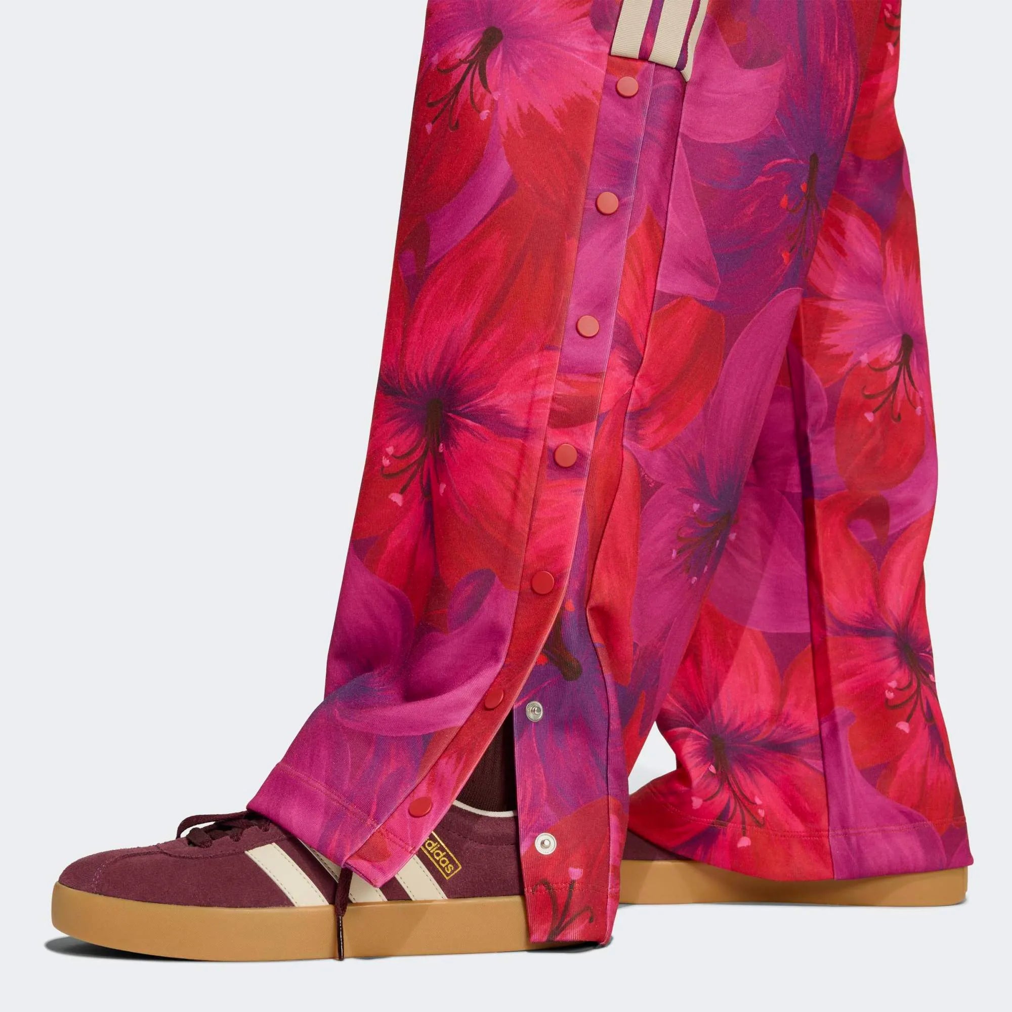 „Frauen adidas x Farm Rio Tiro Trainingshose in Bahia Magenta und Rot mit tropischem Blumenmuster an den Seiten und weißen 3-Streifen bei Stickabush Berlin.“