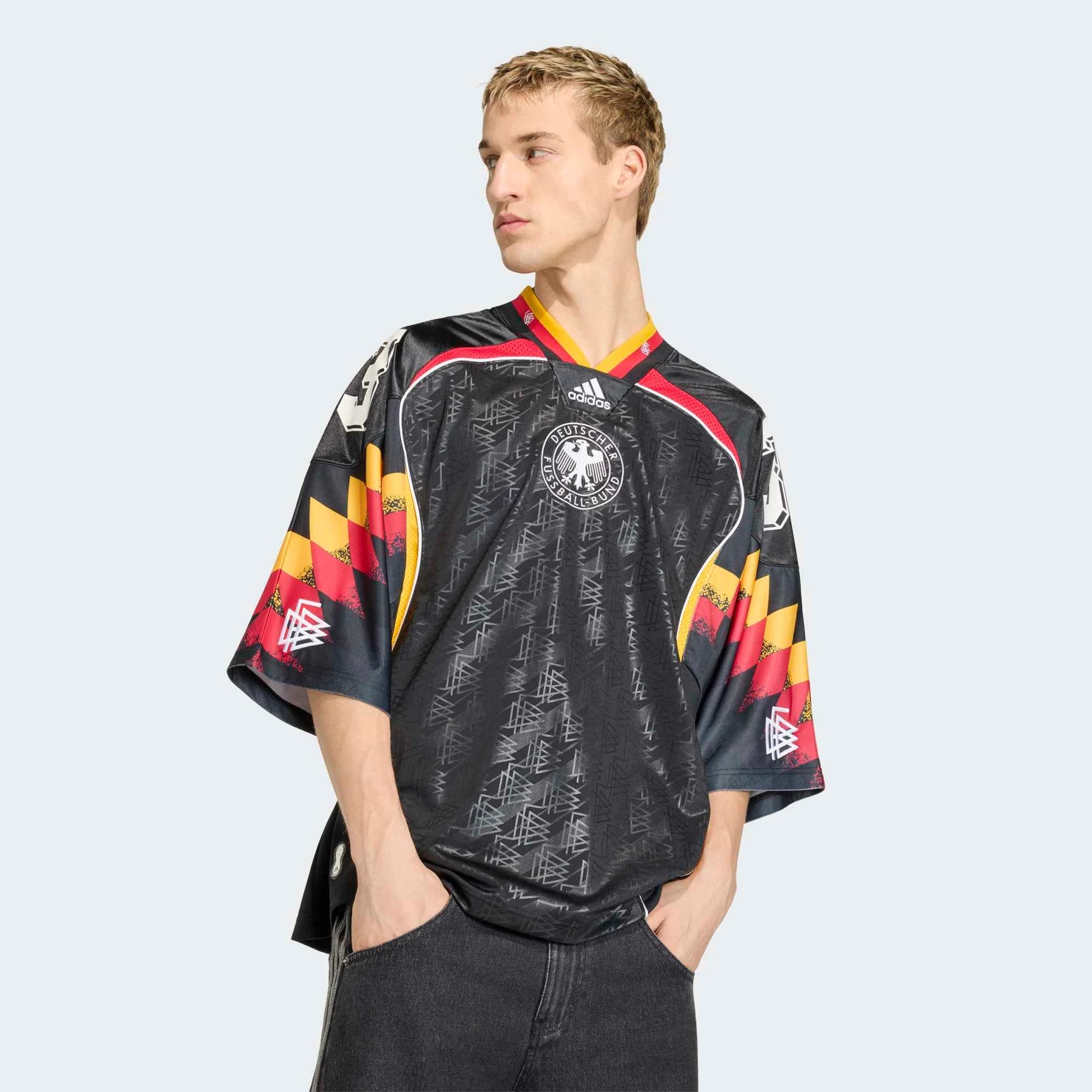 “Vorderansicht Model Outfit des adidas Originals Bringback Remixed DFB Trikots KD5980 in Schwarz mit der großen weißen Nummer 3 und kleinen Nummern an den Schultern bei Stickabush.“