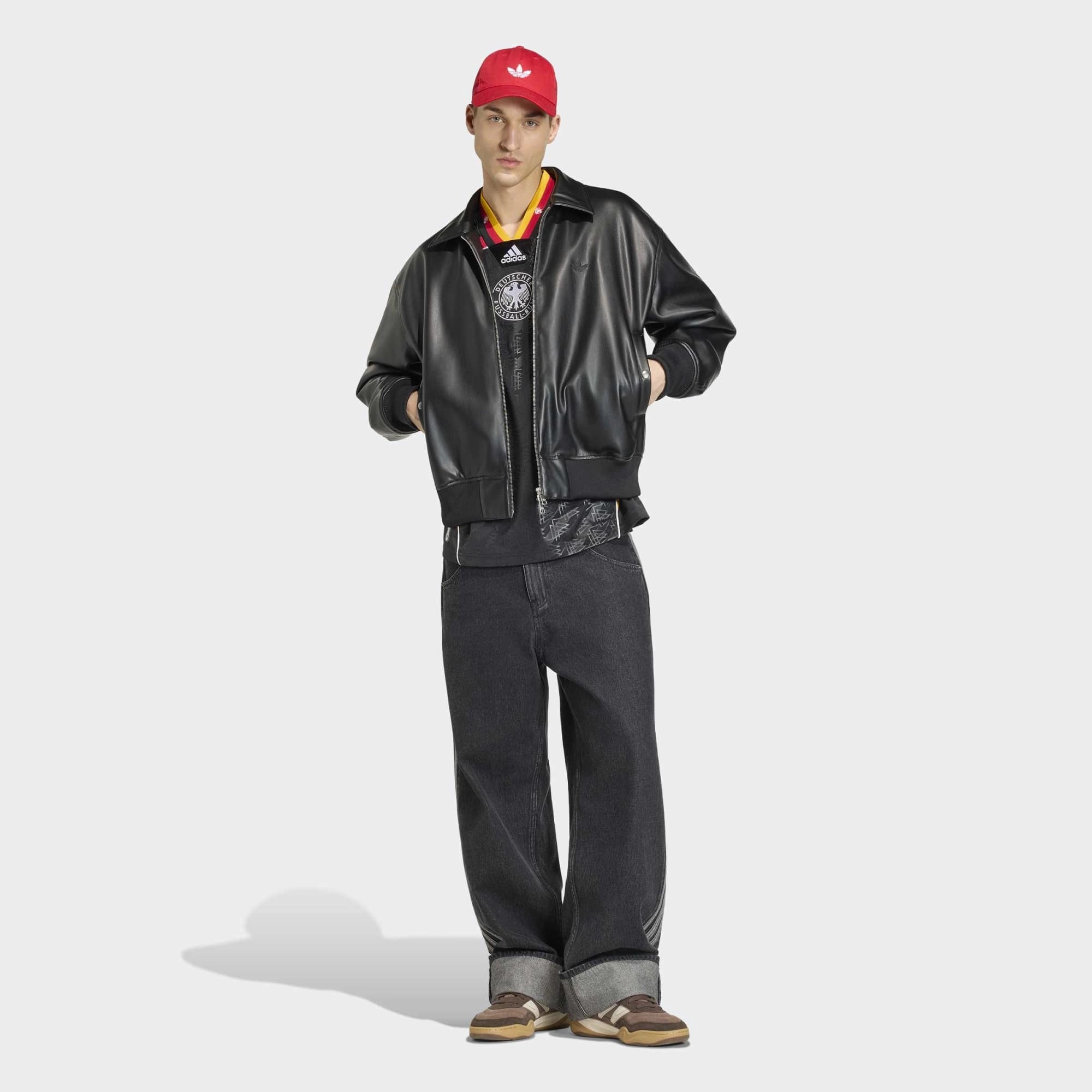 “Vorderansicht Model Jacke des adidas Originals Bringback Remixed DFB Trikots KD5980 in Schwarz mit der großen weißen Nummer 3 und kleinen Nummern an den Schultern bei Stickabush.“