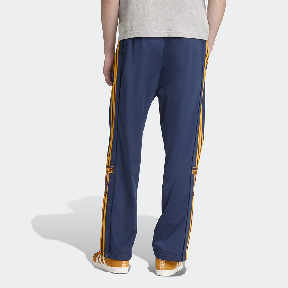 "Adidas Adibreak Track Pants in Blau/Orange, 100% recyceltes Trikot-Material, mit orangefarbenen 3-Streifen und seitlichen Druckknöpfen.“