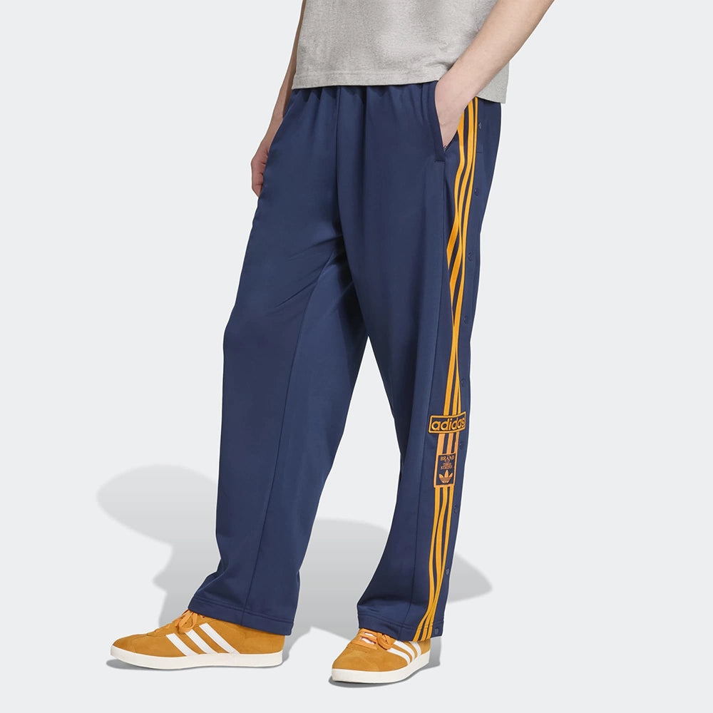 "Adidas Adibreak Track Pants in Blau/Orange, 100% recyceltes Trikot-Material, mit orangefarbenen 3-Streifen und seitlichen Druckknöpfen.“