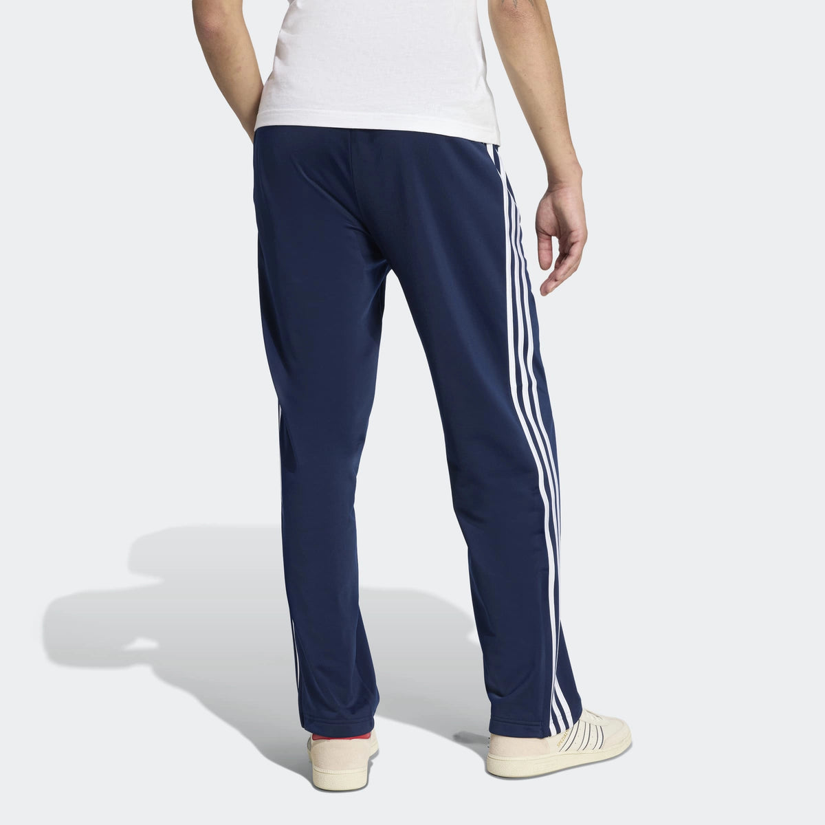 adidas Originals Firebird Track Pants in Night Indigo – Rueckansicht am Model der dunkelblauen Trainingshose im Retro-Look mit den ikonischen 3-Stripes.