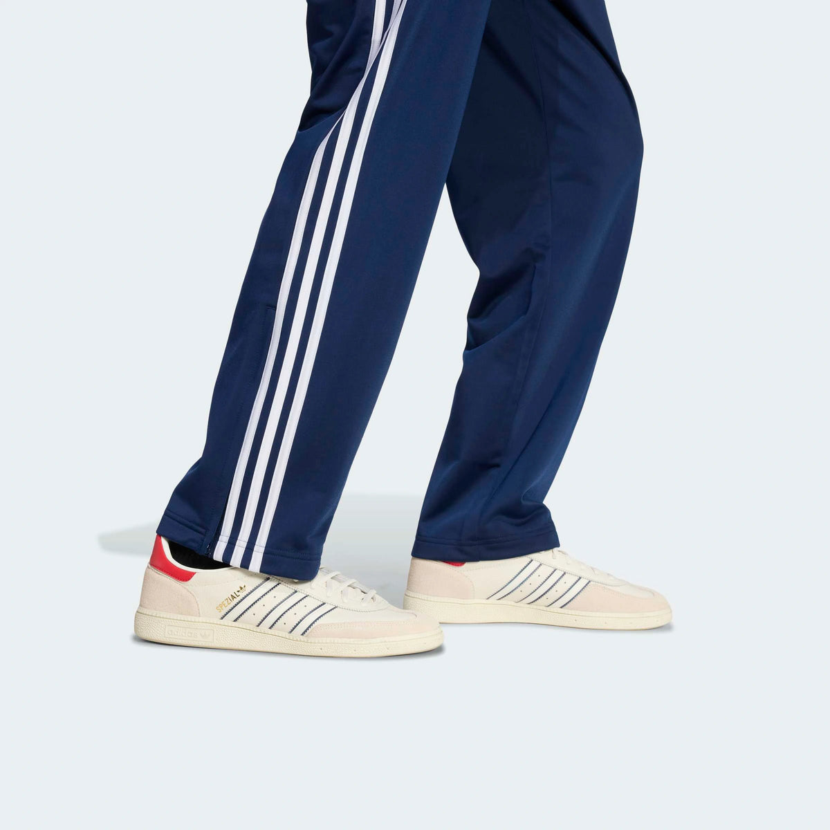 adidas Originals Firebird Track Pants in Night Indigo – Vorderansicht Details am Model der dunkelblauen Trainingshose im Retro-Look mit den ikonischen 3-Stripes.