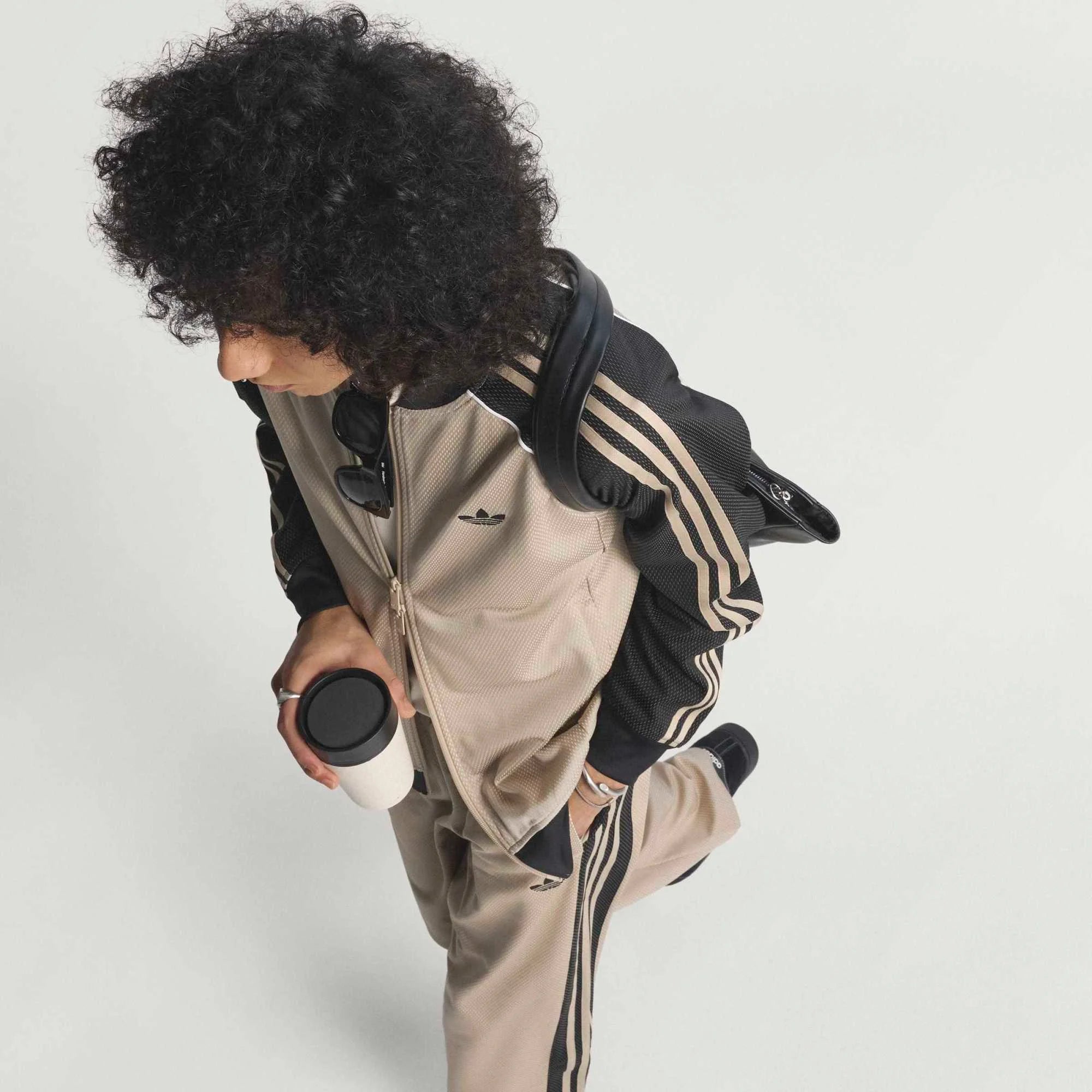 "adidas Originals SST Loose Mesh Track Top in Stone Khaki mit transparentem Mesh-Gewebe und weißen 3-Streifen auf den Ärmeln bei Stickabush Berlin.“
