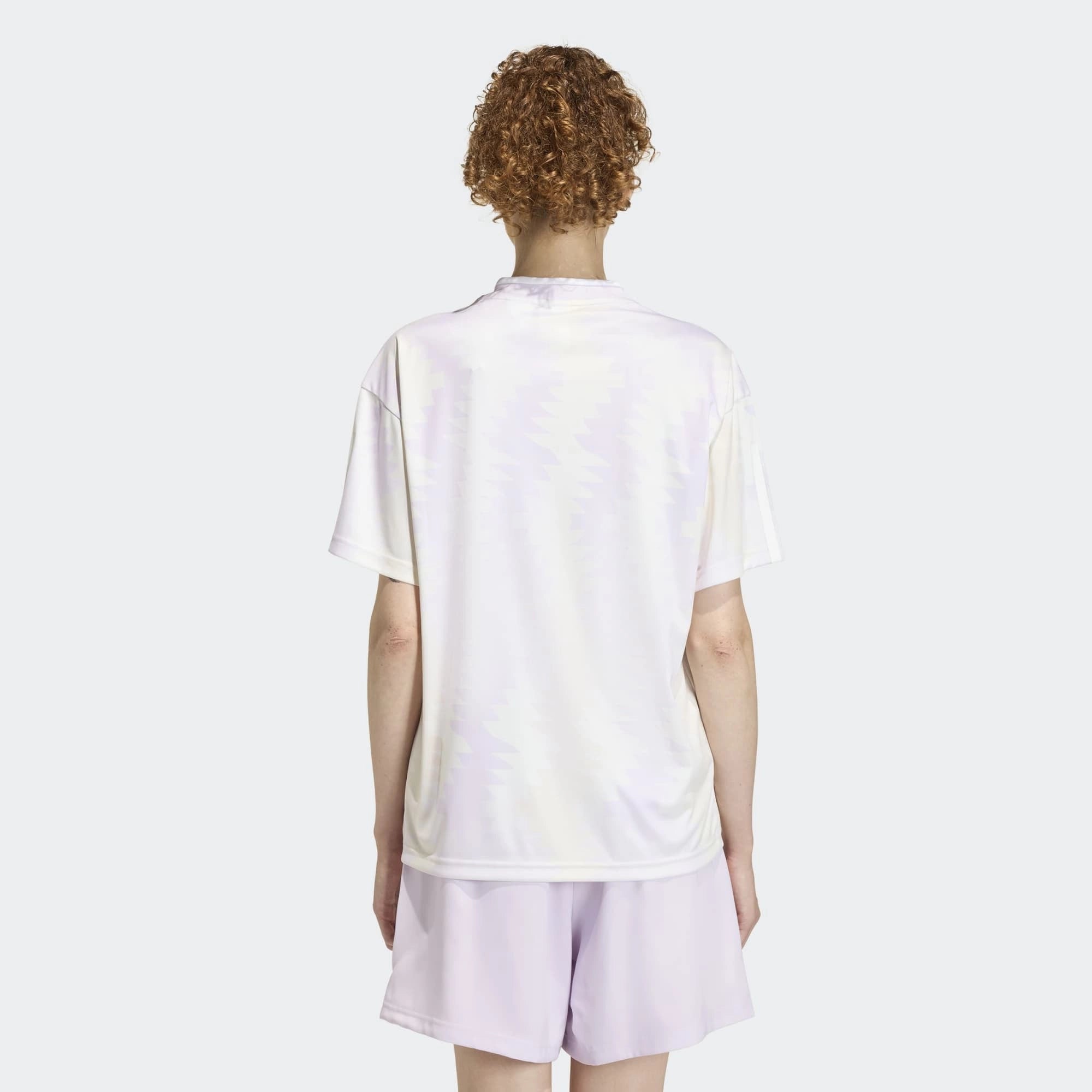 “Weißes Adidas House of Tiro X Common Goal Trikot für Damen mit dezenten lavenderfarbenen Details und klassischem V-Ausschnitt bei Stickabush Berlin.“